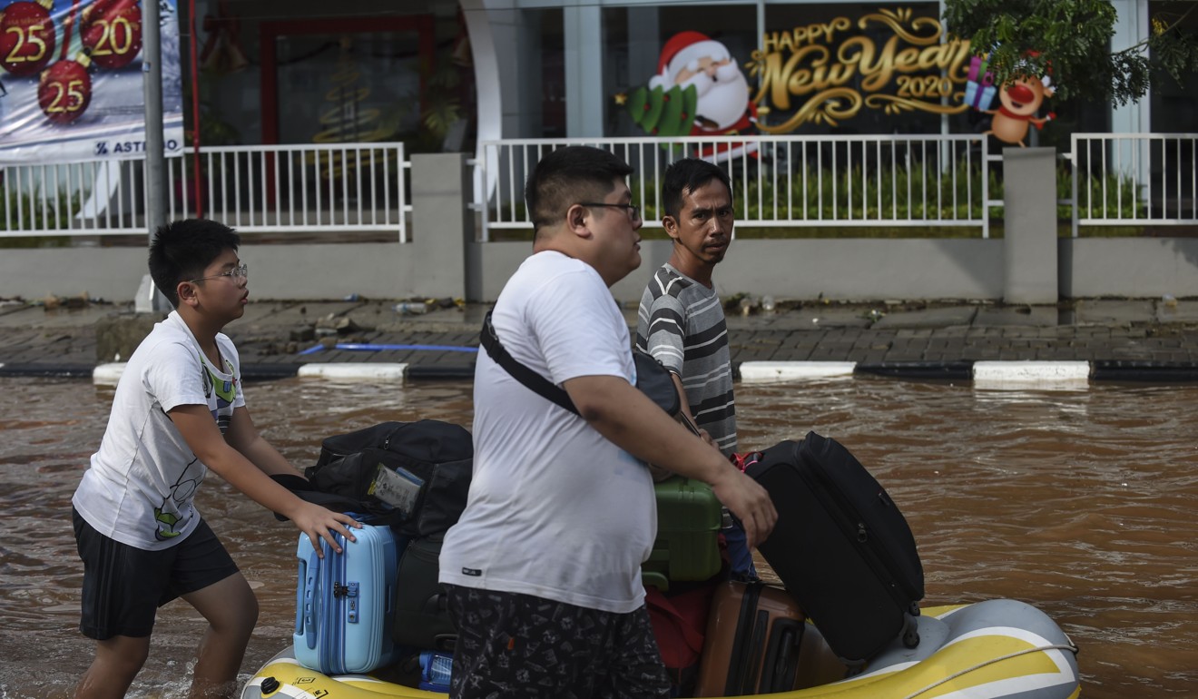 People transfer their belongings by rubber boat on a flooded street in Jakarta. Photo: Xinhua
