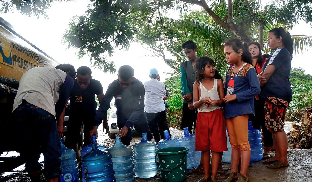 People wait to get fresh water from a truck in Bekasi. Photo: AFP