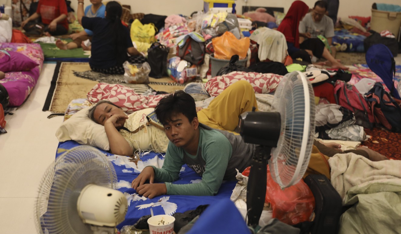 People rest at a temporary shelter for those affected by the floods. Photo: AP