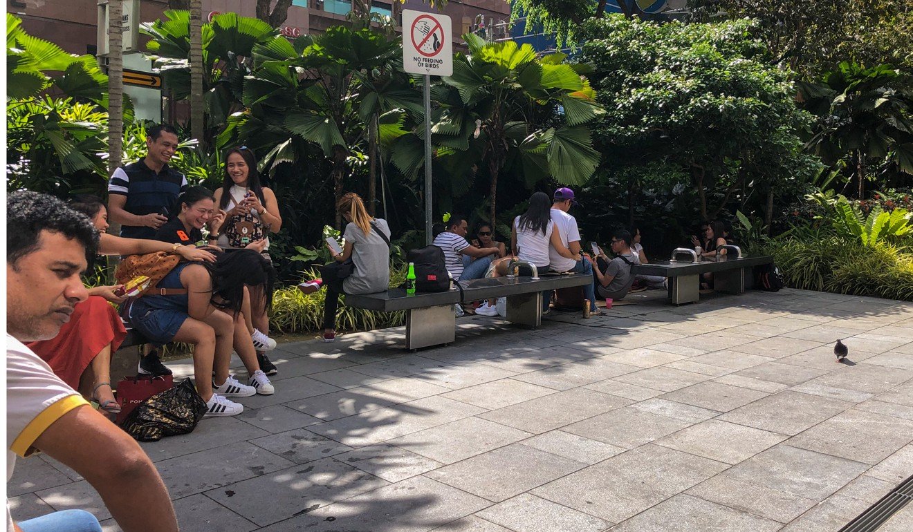 Fearing for their safety, foreign workers have moved from the narrow pavement next to Lucky Plaza to broader open spaces. Photo: Kok Xinghui