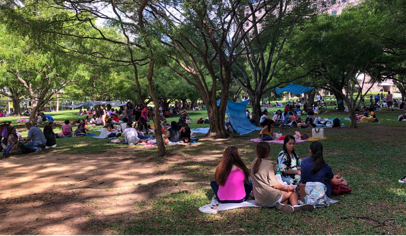 Domestic workers gather on a grass patch behind Somerset MRT Station in Singapore. Photo: Kok Xinghui