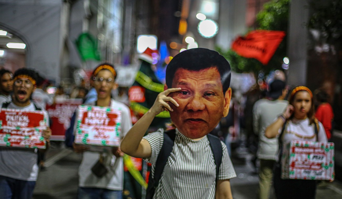 A protester with a Duterte mask takes part in a march to mark International Human Rights Day in Manila. Photo: AFP