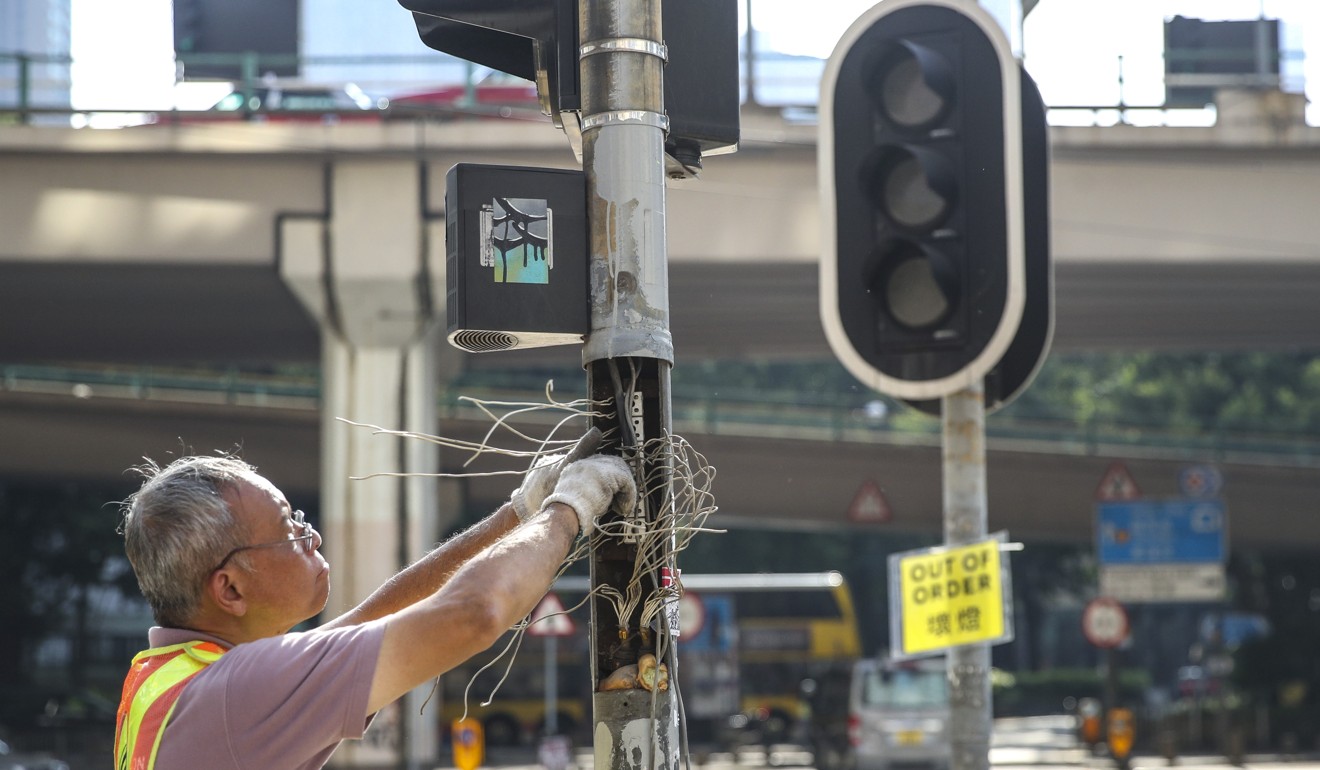 A worker repairs a broken traffic light in Causeway Bay. Photo: Winson Wong