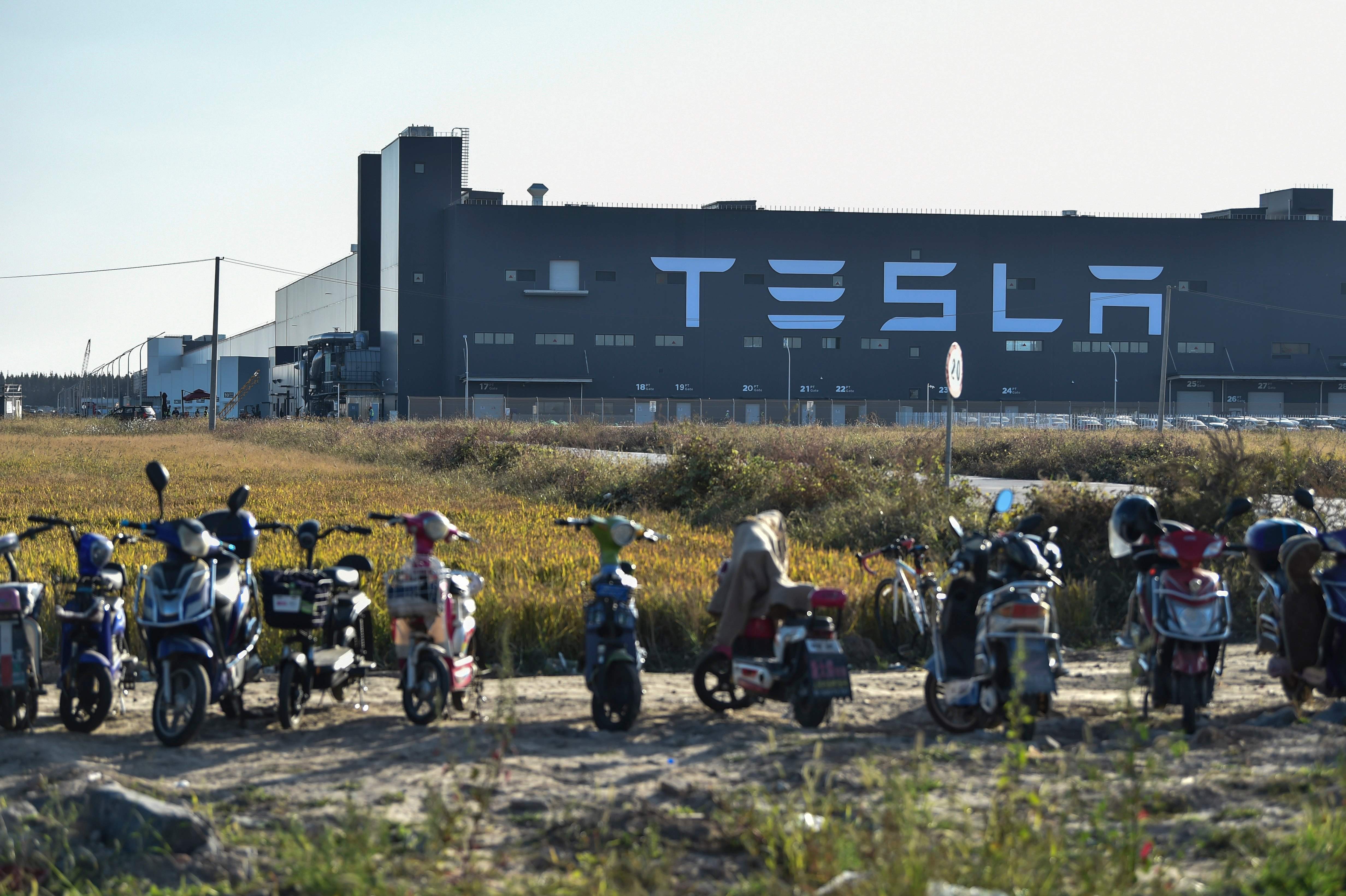 Scooters are parked near the new Tesla factory in Shanghai. The Chinese economy has slowed but Beijing has the power to kick-start a virtuous cycle of growth and development. Photo: AFP
