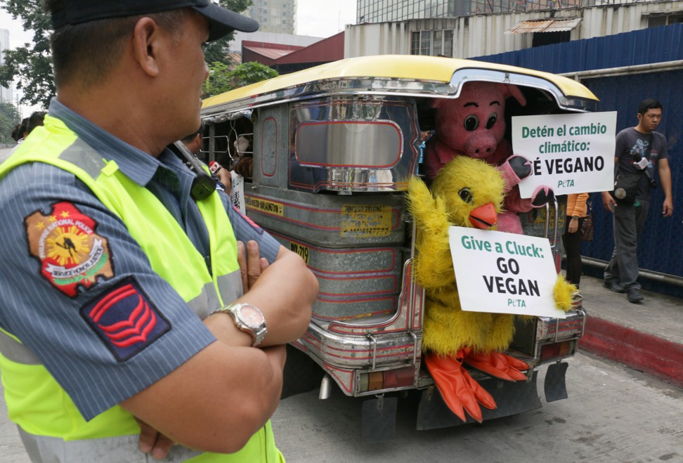 Activists from People for the Ethical Treatment of Animals display placards from the back of a jeepney recommending a vegan diet in Manila. Photo: AFP