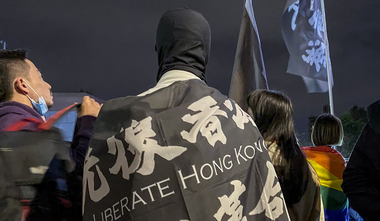 A Hong Kong protester at the Taiwan rally is draped in a flag bearing the movement’s rallying cry of ‘Liberate Hong Kong; revolution of our times’. Photo: Kimmy Chung