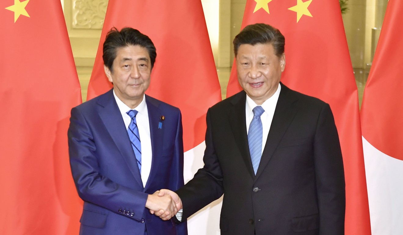 Japanese Prime Minister Shinzo Abe and Chinese President Xi Jinping shake hands ahead of their talks in Beijing on December 23. Xi will visit Japan in the spring. Photo: Kyodo