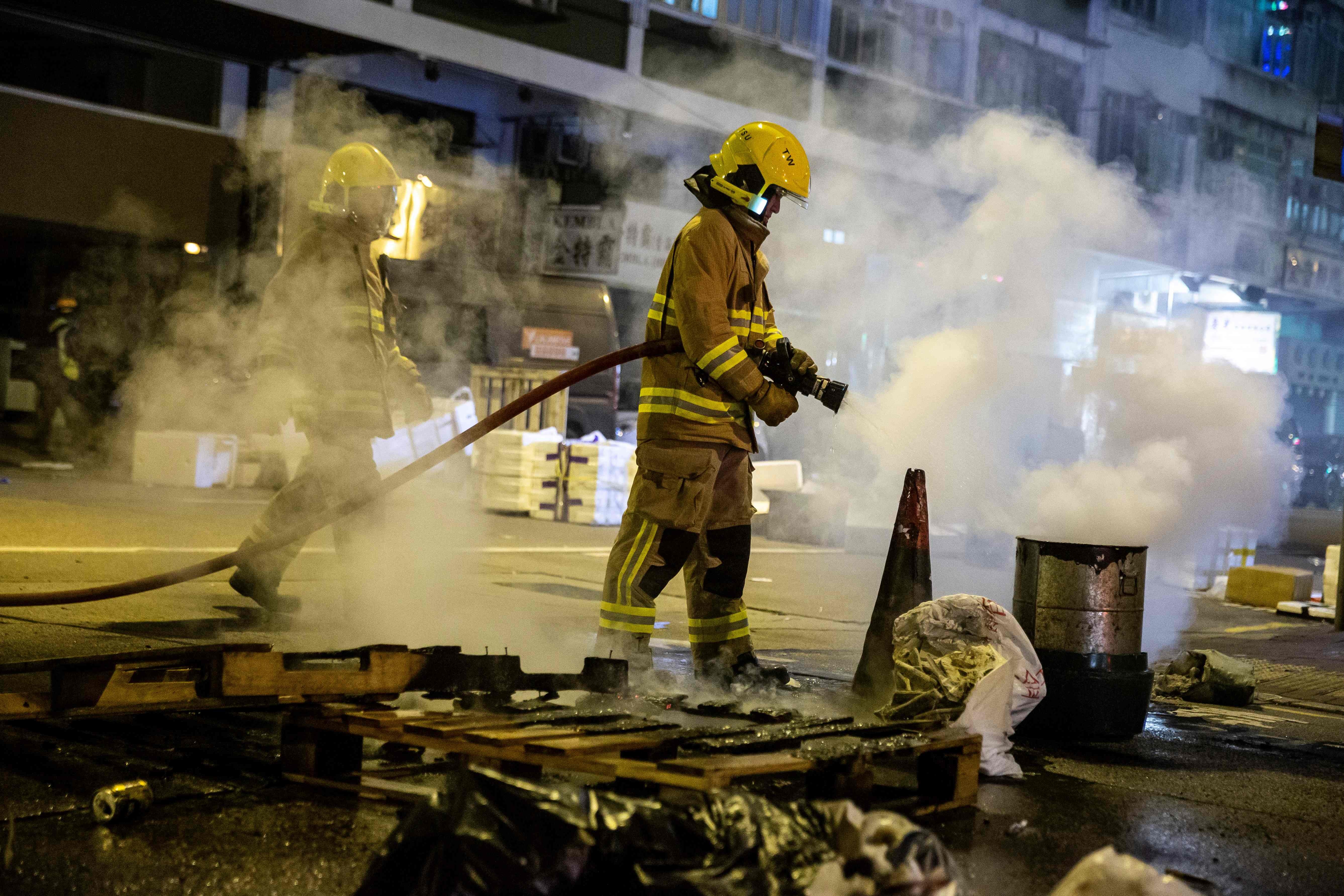 A firefighter puts out a fire started by protesters in Kowloon on December 31. Photo: AFP