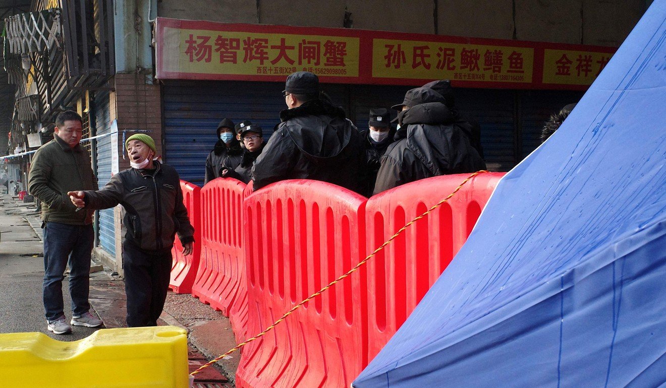 A store owner argues with security guards as he attempts to enter the closed Huanan wholesale seafood market in Wuhan recently. Photo: AFP