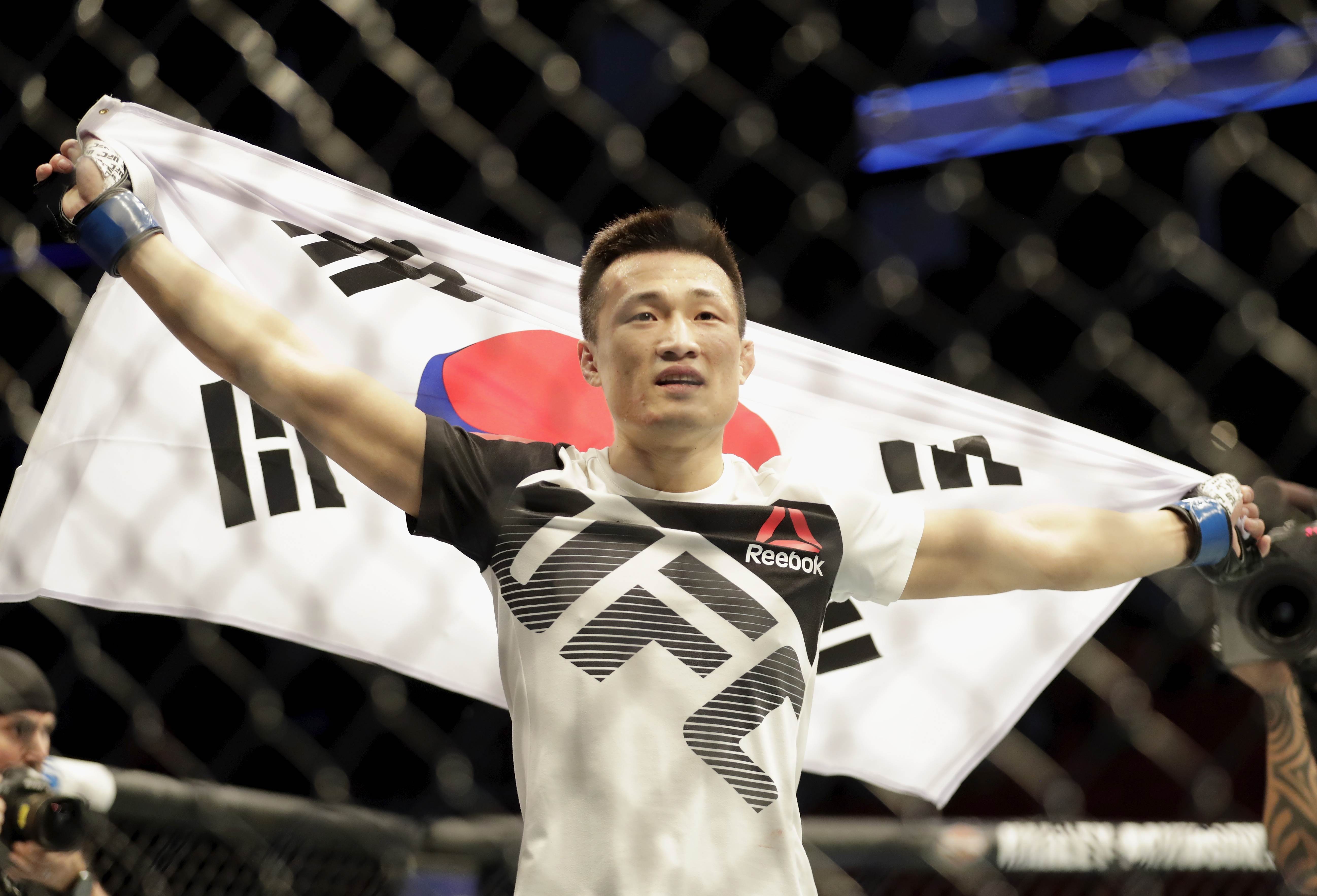 Jung Chan-sung celebrates with his native flag after defeating Dennis Bermudez in 2017. Photo: AFP