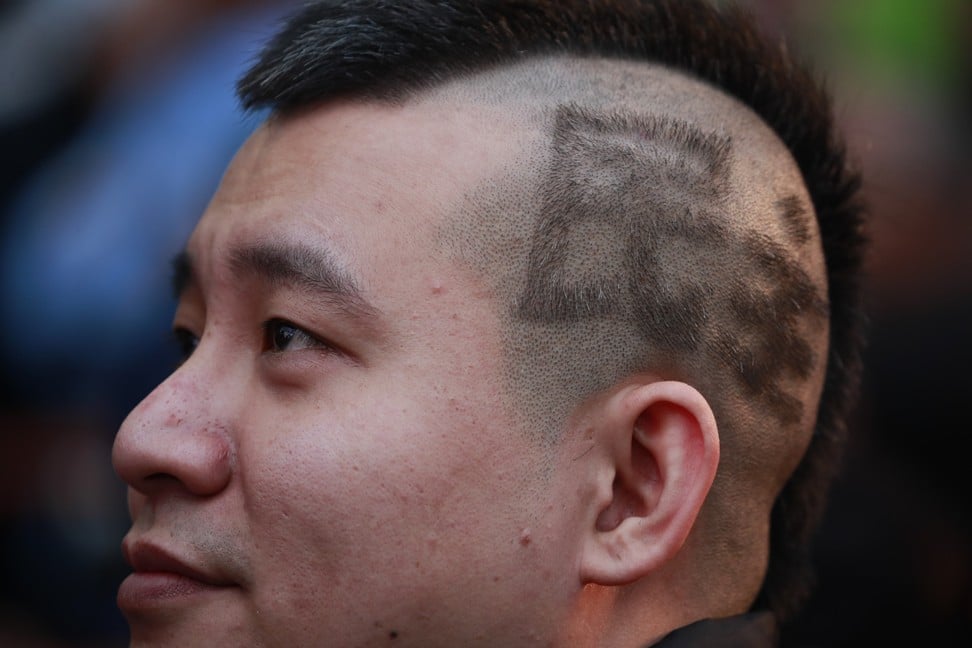 A supporter of Taiwan’s President Tsai Ing-wen with the word “democracy” cut into his hair. Photo: EPA