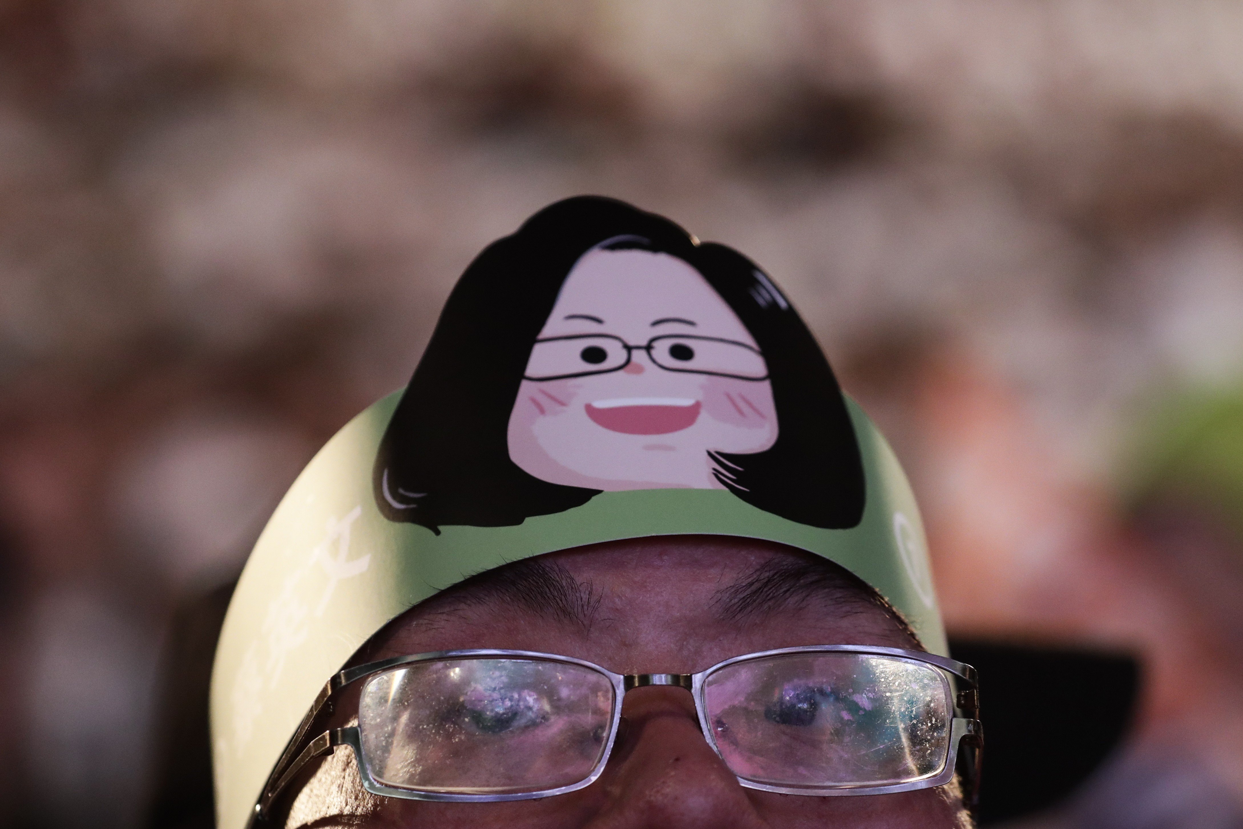 A man wears a headband showing a drawing of Taiwan's President Tsai Ing-wen during an election campaign. Photo: EPA