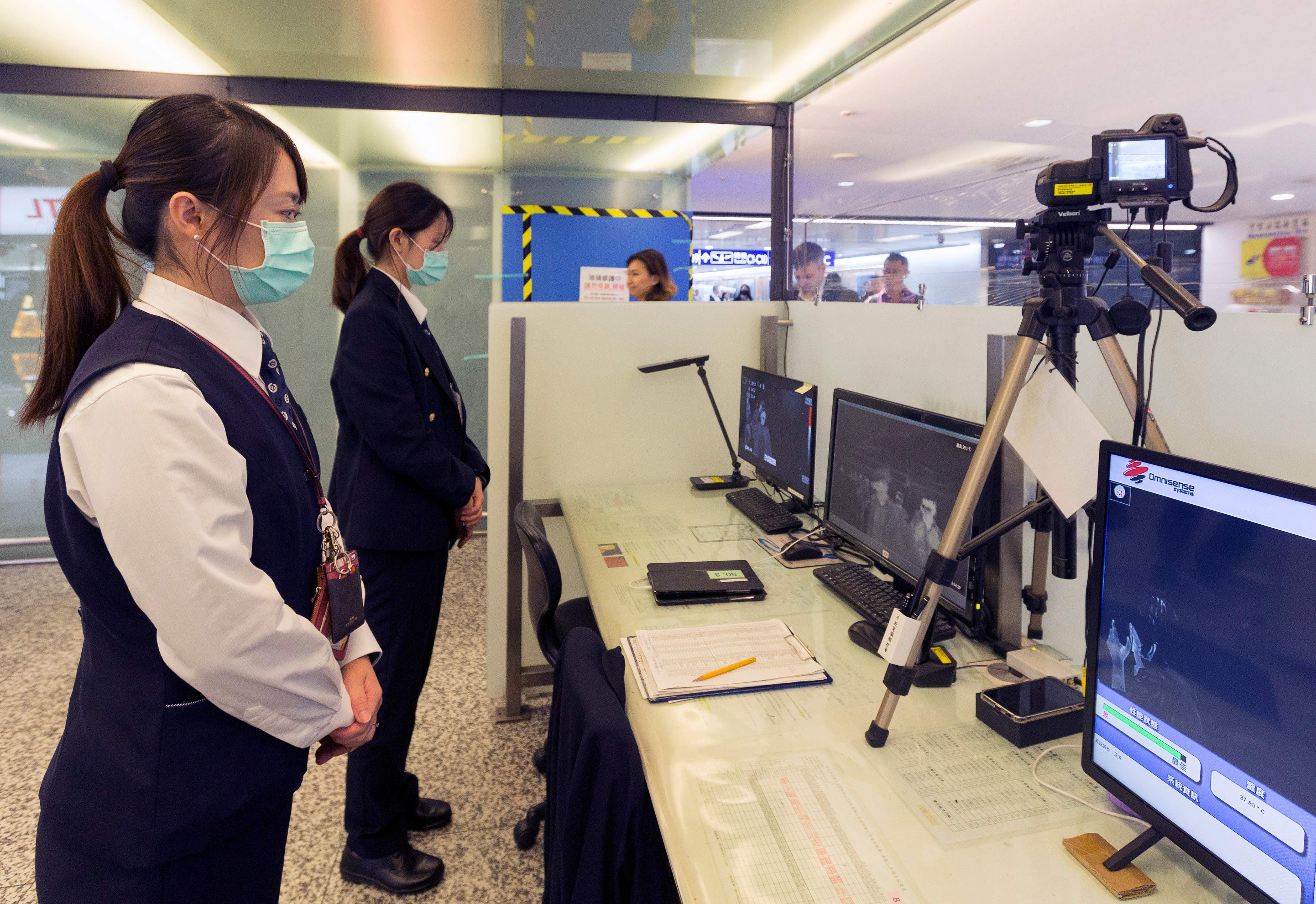 Staff from Taiwan's Centre for Disease Control use thermal scanners to screen passengers arriving on a flight from Wuhan. Photo: AFP