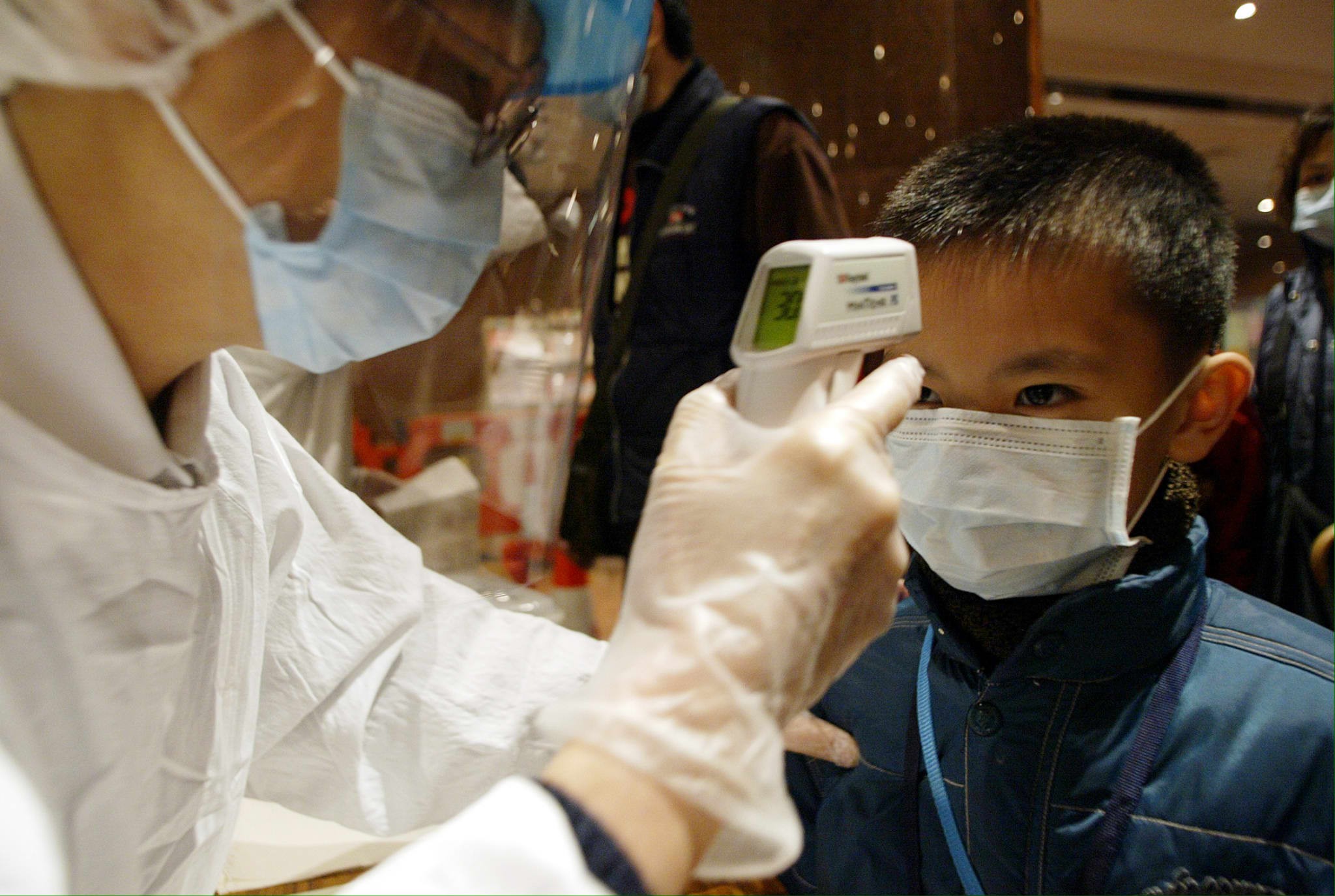 A boy has his temperature taken as he arrives at the Queen Elizabeth Hospital on January 20, 2004, where a man was in isolation after showing Sars-like symptoms. Hong Kong had been declared Sars-free the previous year, after 299 died of the disease. Photo: AFP