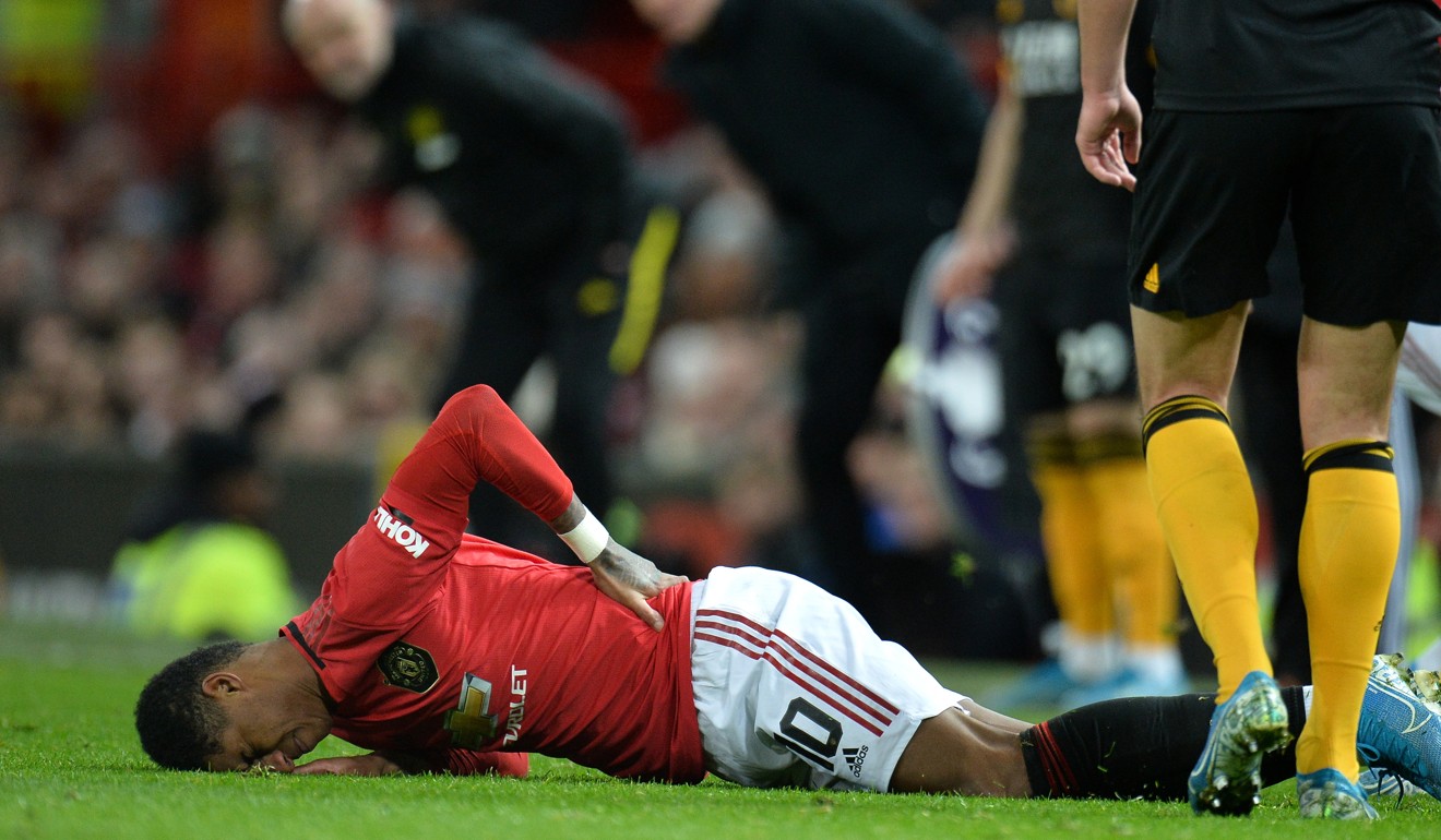 Marcus Rashford holds his back in pain during the English FA Cup match against Wolverhampton Wanderers. Photo: EPA
