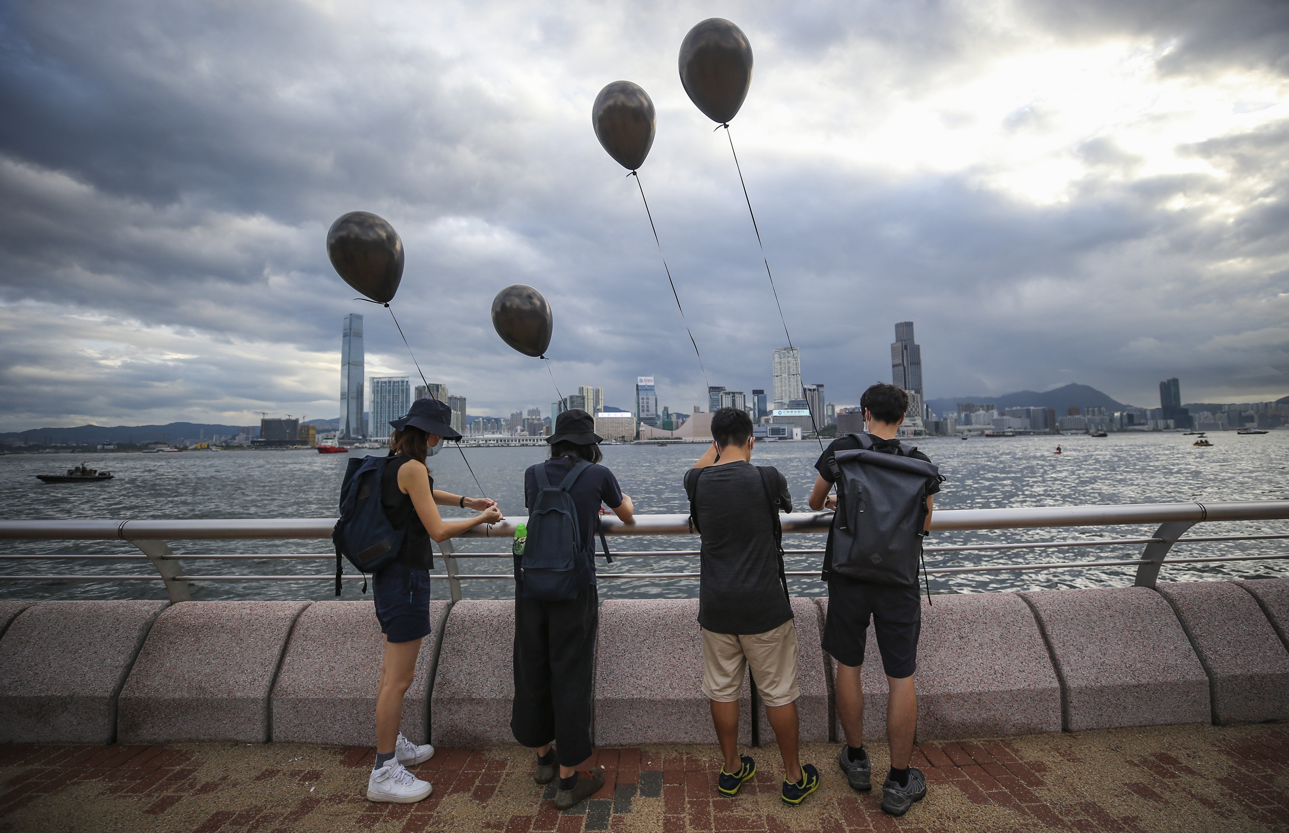 Protesters tie black balloons to the railing at the Wan Chai harbourfront during a protest against the extradition bill on July 1. The protests have continued for over seven months, with Hong Kong slipping into recession in October 2019. Photo: Winson Wong