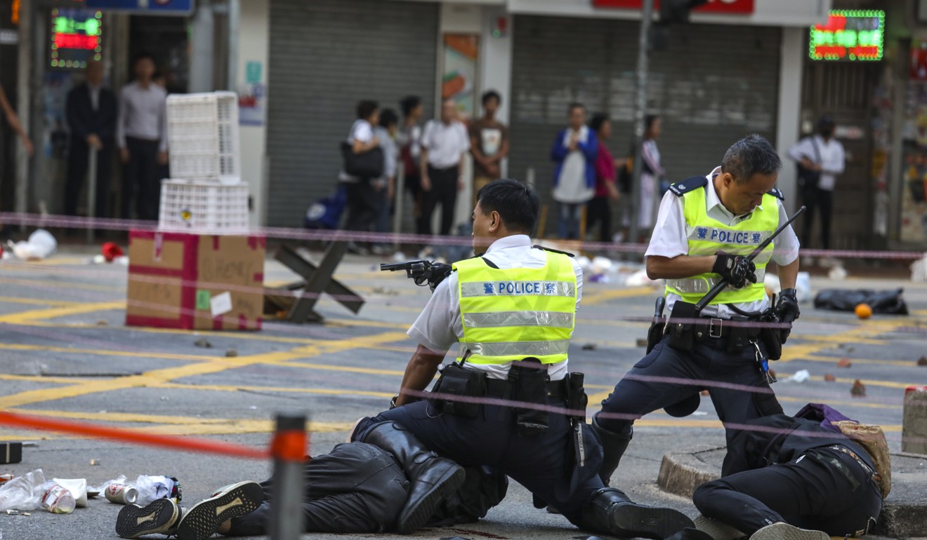 Two police officers hover over a fallen Chow Pak-kwan, who was shot moments earlier on November 11. Photo: Nora Tam