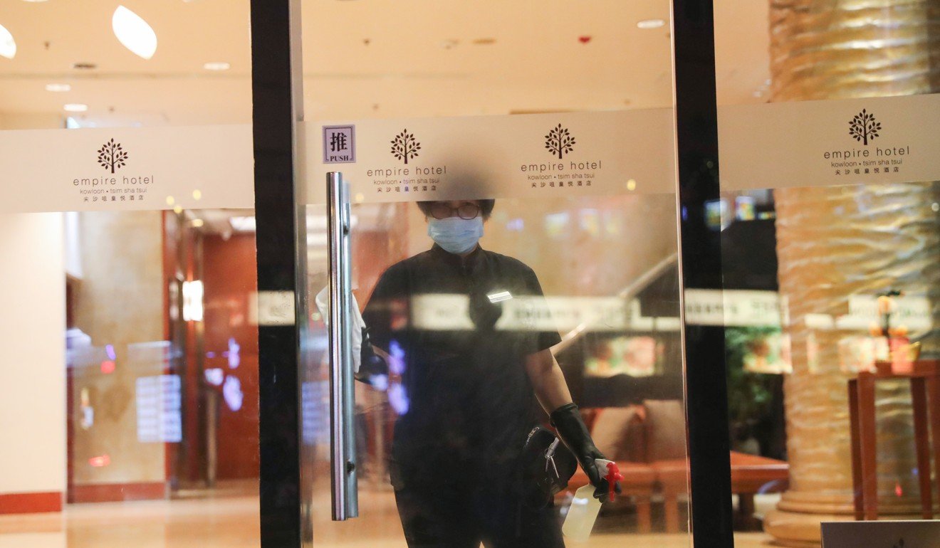 A staff member cleans the lobby doors at the Empire Hotel. Photo: Sam Tsang