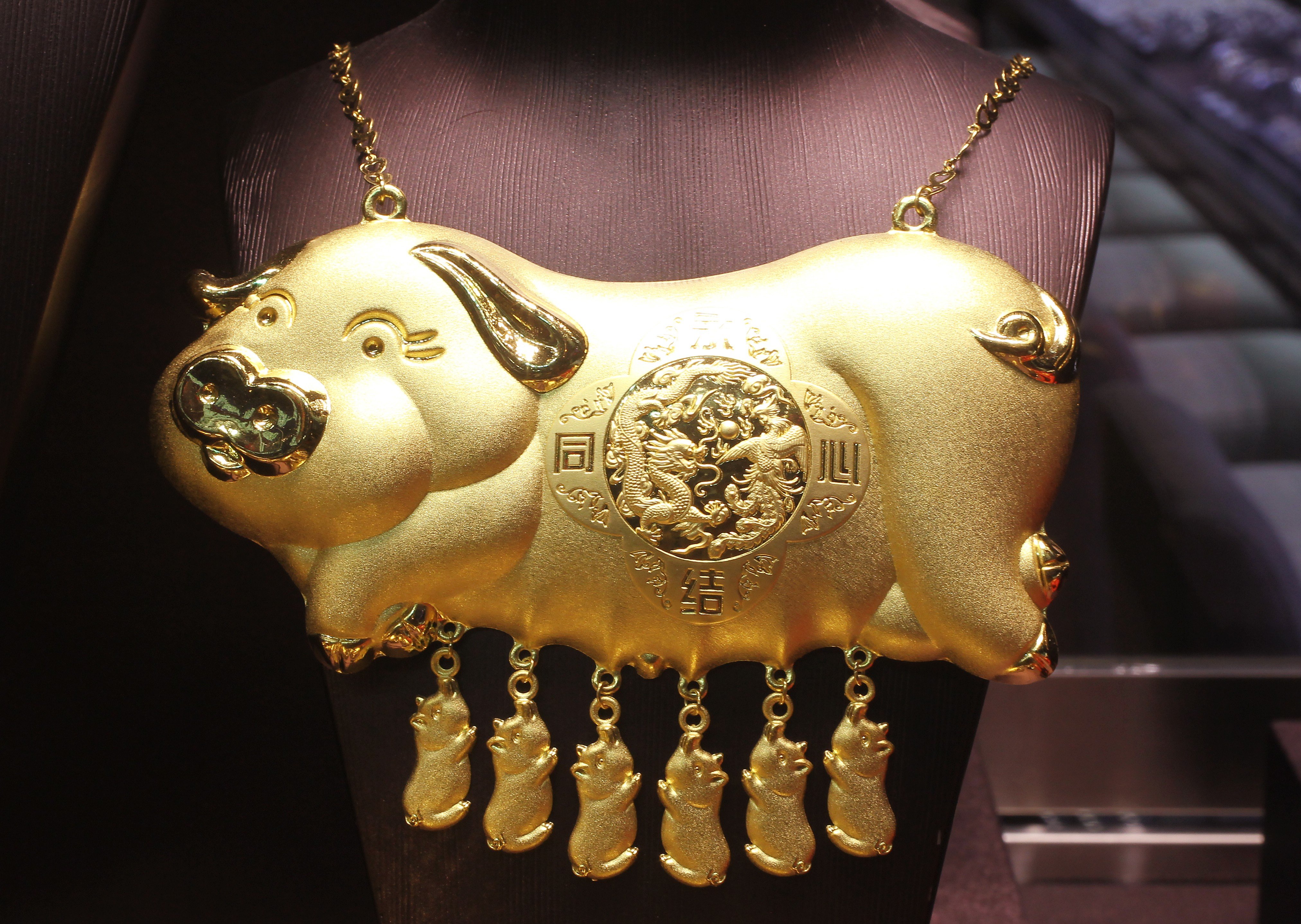 Steeped in tradition, cumbersome pig necklaces continue to be hugely popular with Chinese brides who like to pair it with traditional dresses at their nuptials – such as this gold pig necklace displayed in a gold shop in Mong Kok, Hong Kong. Photo: Edward Wong