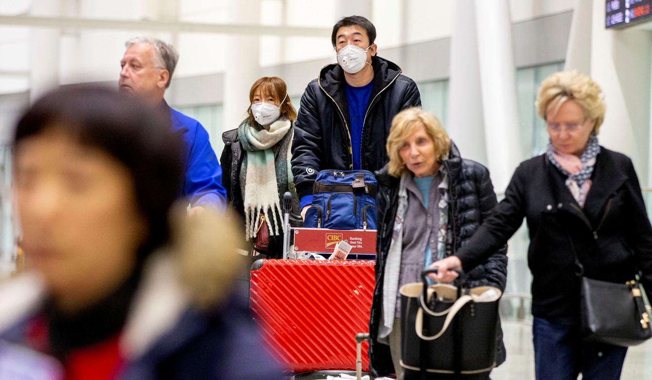 Travellers wear face masks at an airport in Toronto, Canada. Photo: Reuters