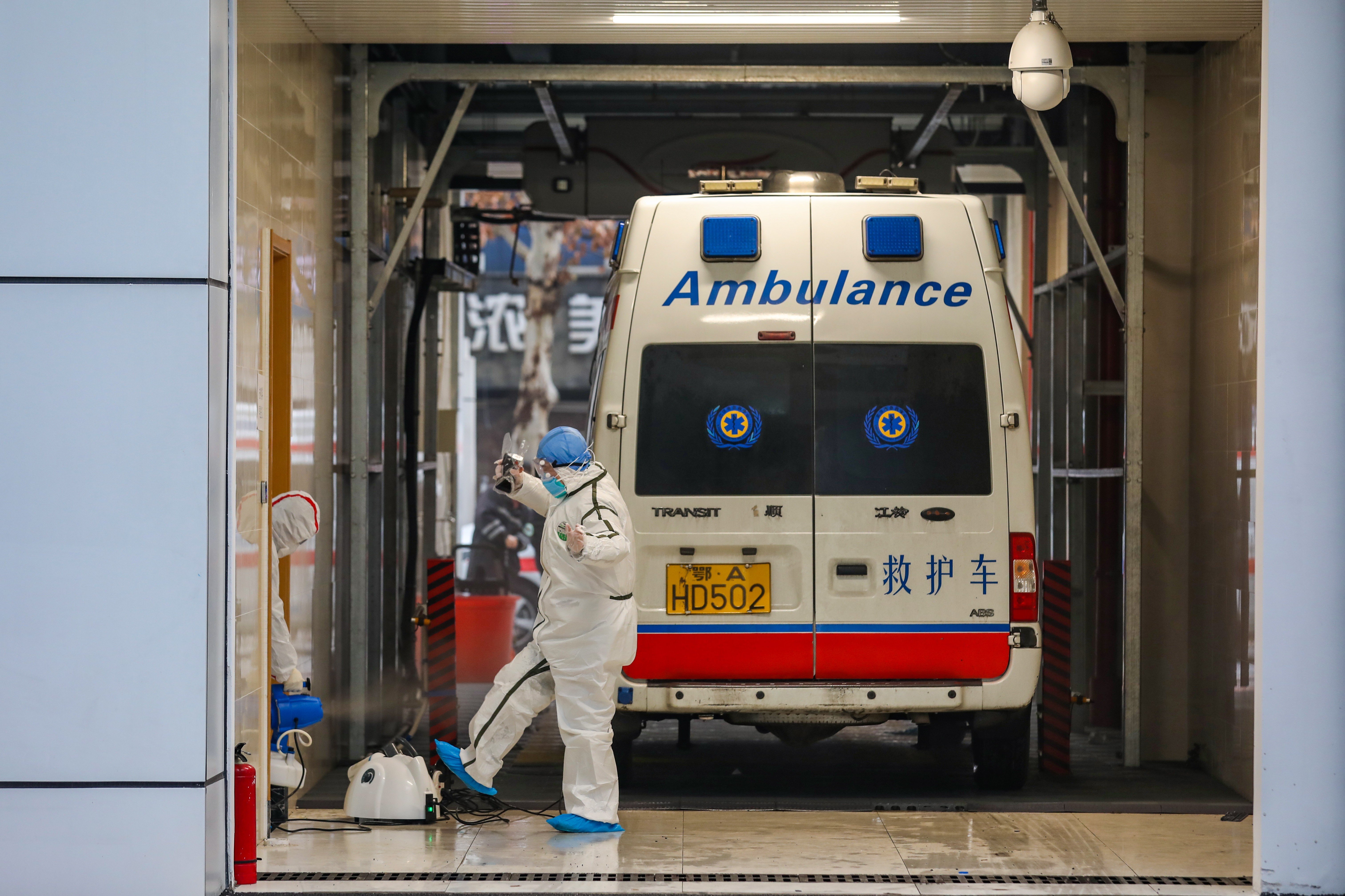 An ambulance crew and their vehicle undergo disinfection procedures in the coronavirus-hit city of Wuhan in central China. Photo: EPA-EFE