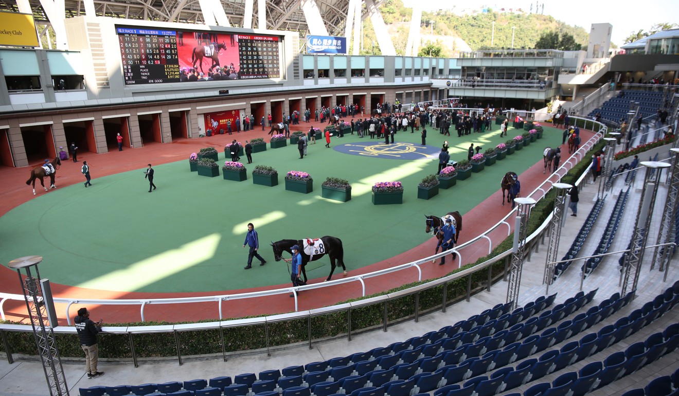 Connections of horses in the opening race at Sha Tin mingle in front of the empty stands. Photo: Kenneth Chan