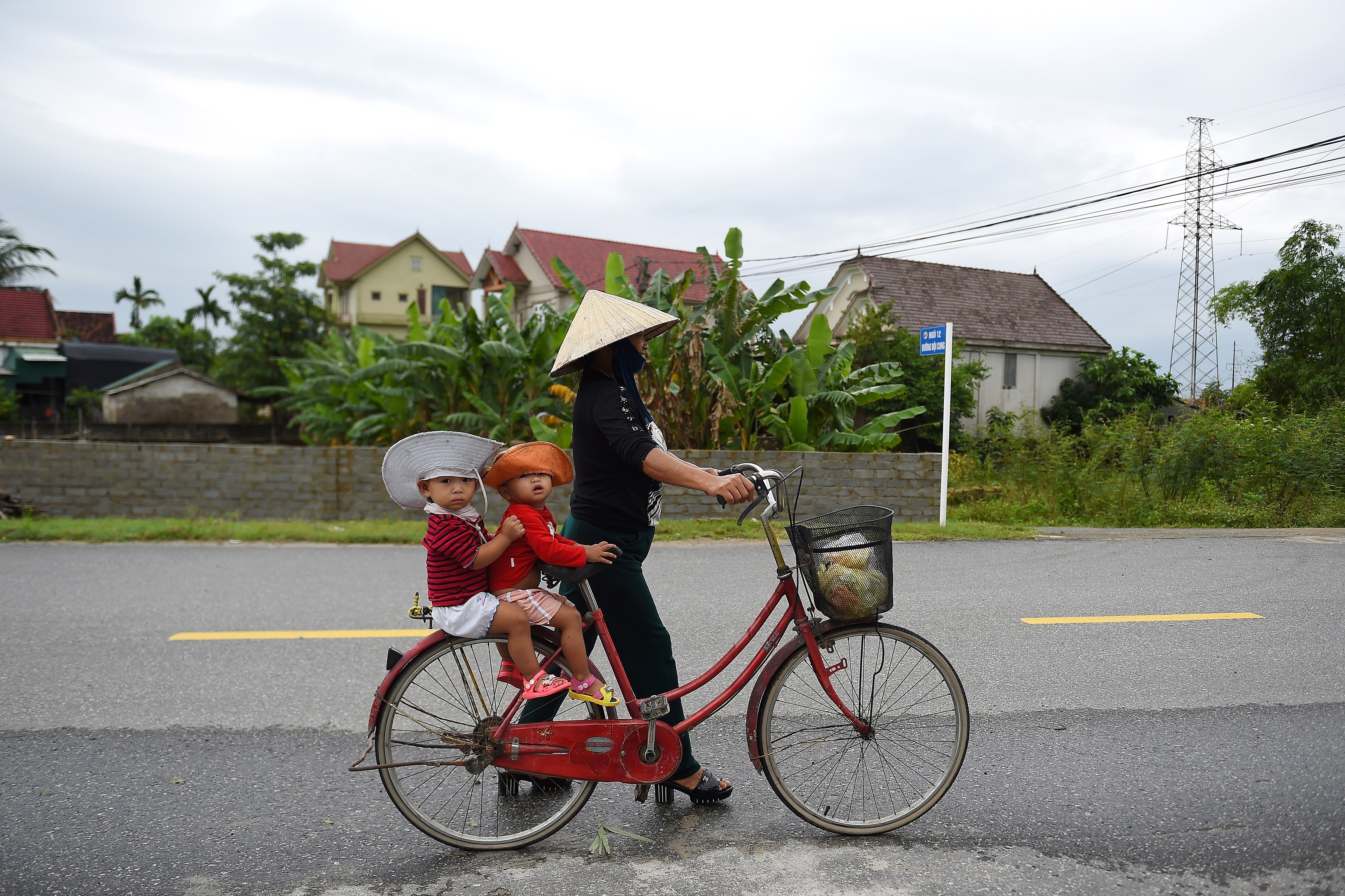 A Vietnamese woman carries children on a bicycle. Vietnam is one of the most region’s promising e-commerce markets, driven by its young population, growing middle class, high internet penetration and rising smartphone penetration. Photo: AFP
