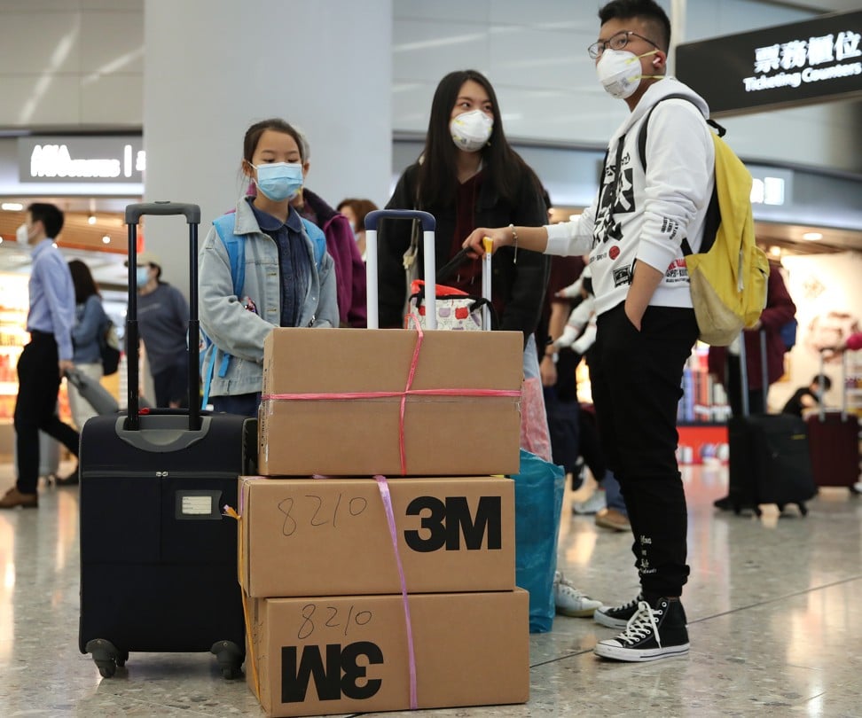 Travellers with boxes of N95 masks at the High Speed Rail Station in West Kowloon, Hong Kong, last week. Photo: SCMP / Winson Wong