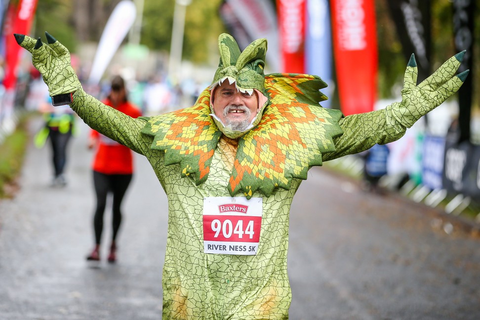 A runner crosses the finish line in Scotland’s Loch Ness Marathon.