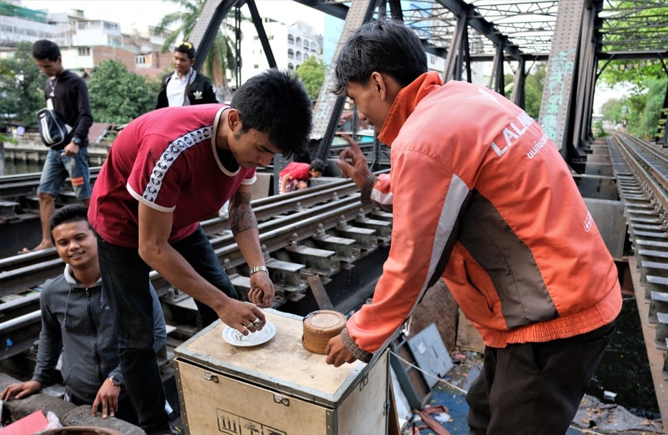 Young people from a shantytown situated by a railway line gamble by the tracks. Photo: Tibor Krausz