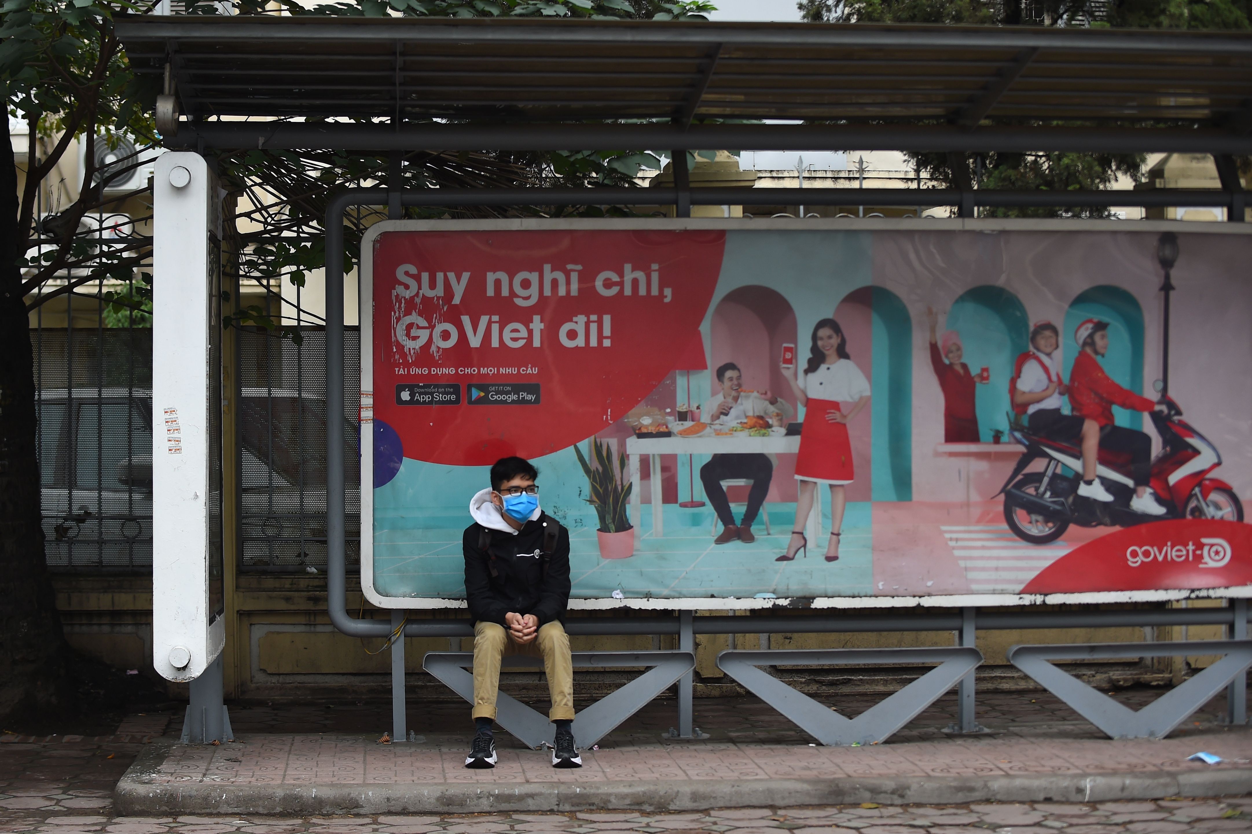 A man wearing a protective facemask sits at a bus stop in Hanoi amid rising concerns over the novel coronavirus outbreak. Photo: AFP