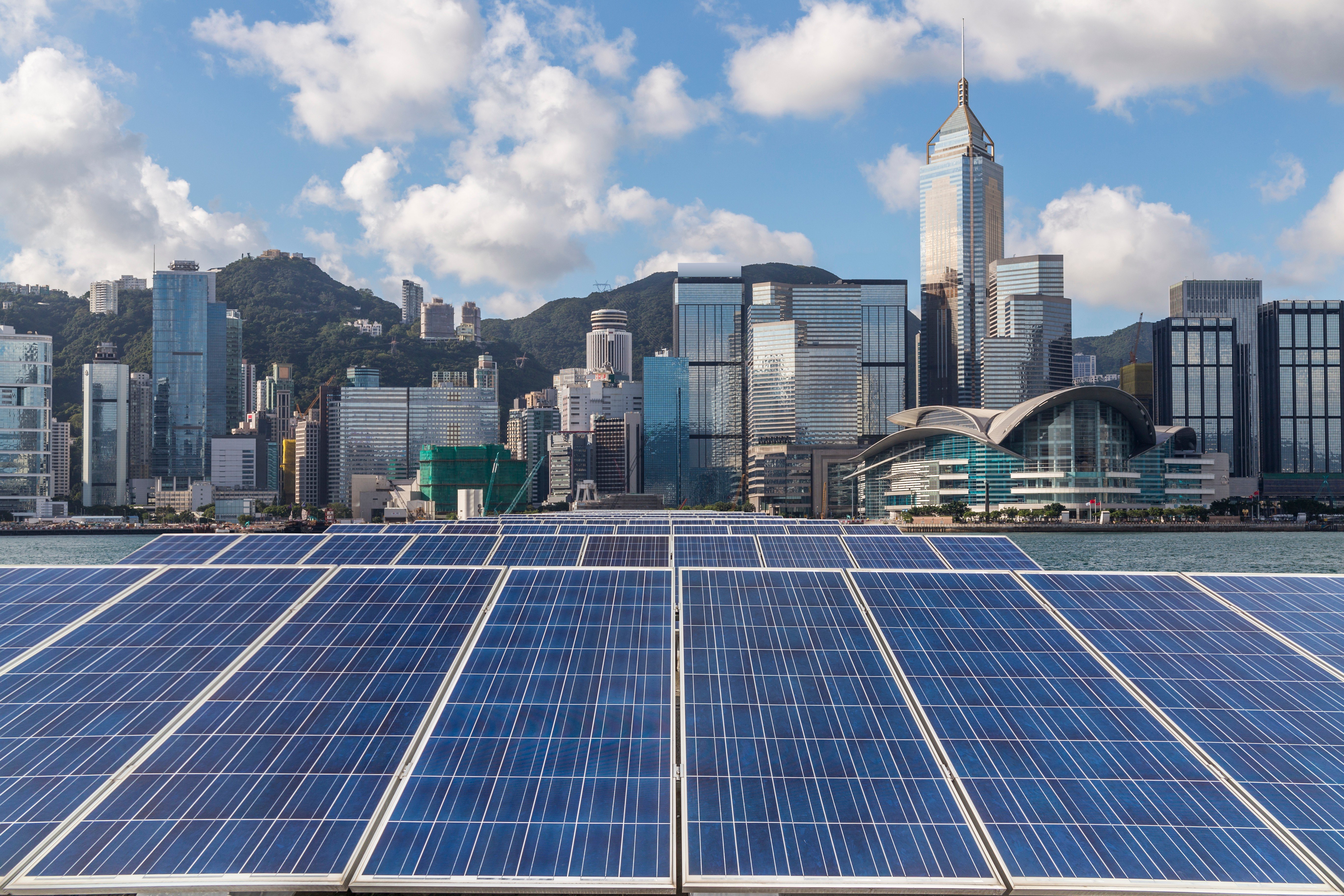 Solar panels are flanked by the Hong Kong skyline. It is already possible to reduce emissions from cities by 90 per cent using proven low-carbon measures such as solar power, mass transit and improved recycling. Photo: Shutterstock