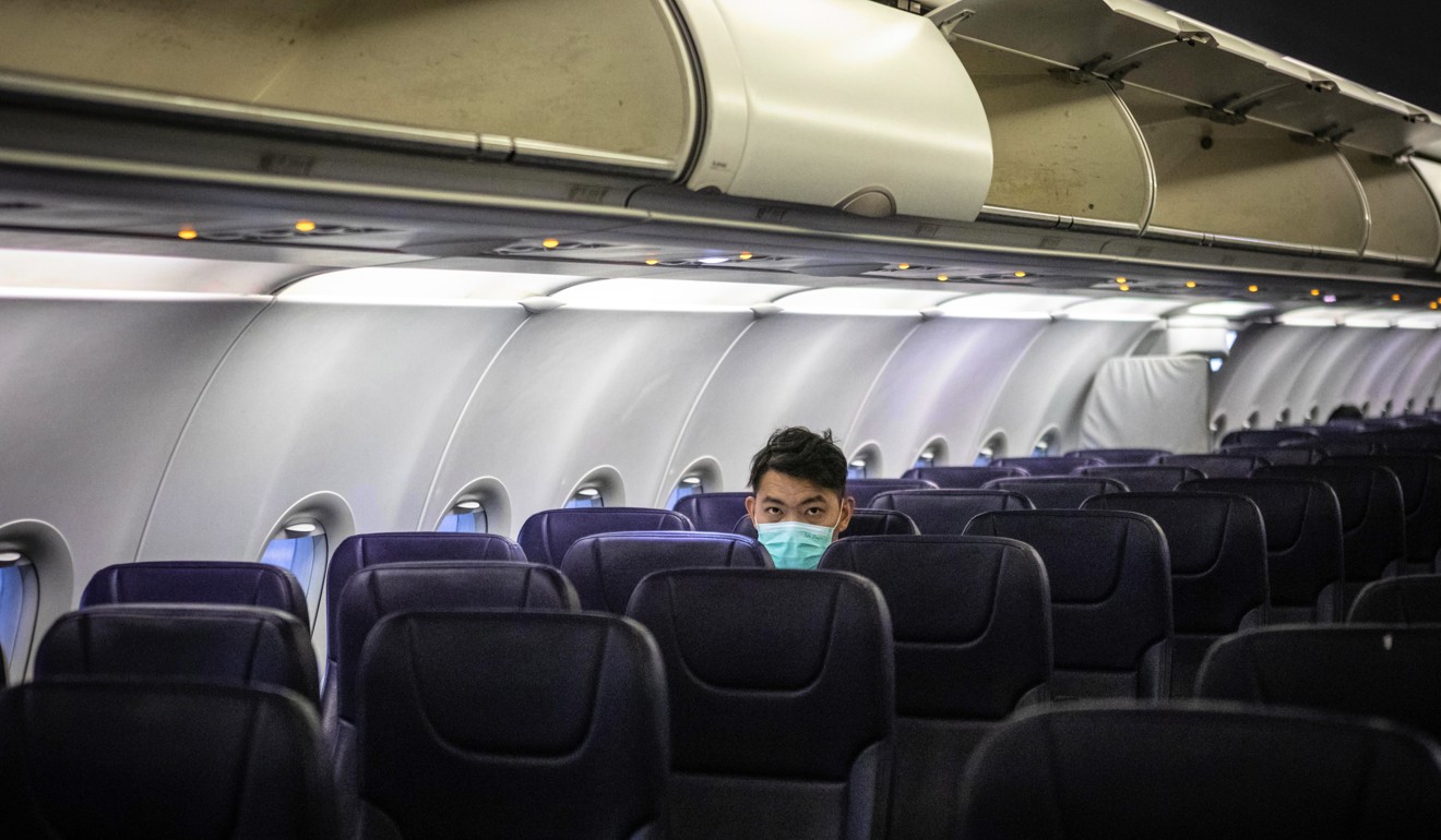 A passengers wearing a protective face mask sits on a plane bound from Cambodia’s Sihanoukville to Guangzhou on Saturday. Photo: EPA