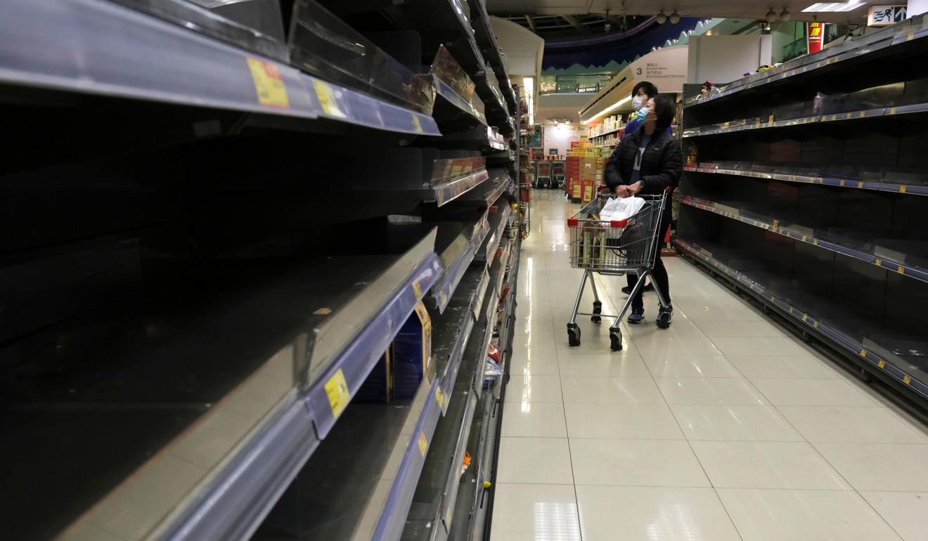 Grocery shoppers, wearing masks amid coronavirus fears, encounter empty instant noodle shelves at a supermarket in Hong Kong on January 30. Photo: Reuters