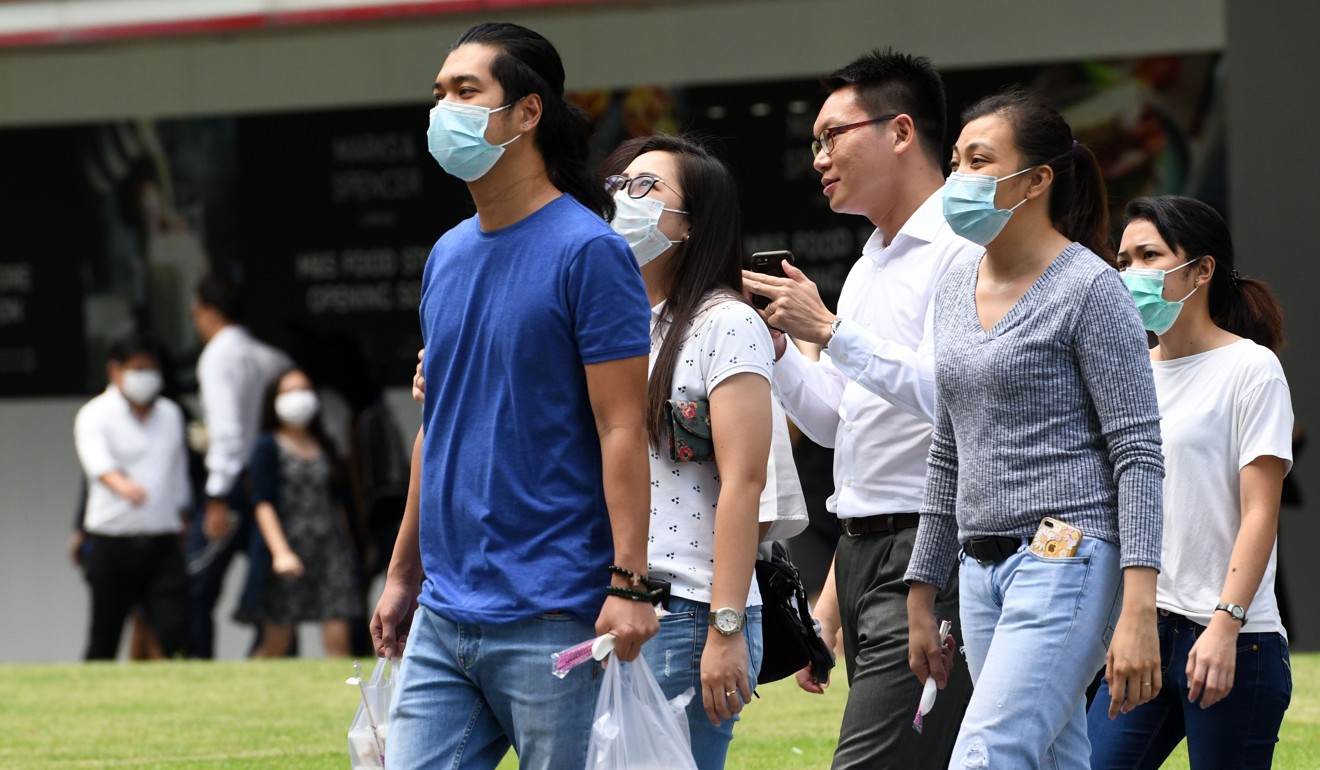 People wear protective face masks in Singapore on Wednesday. Photo: AFP