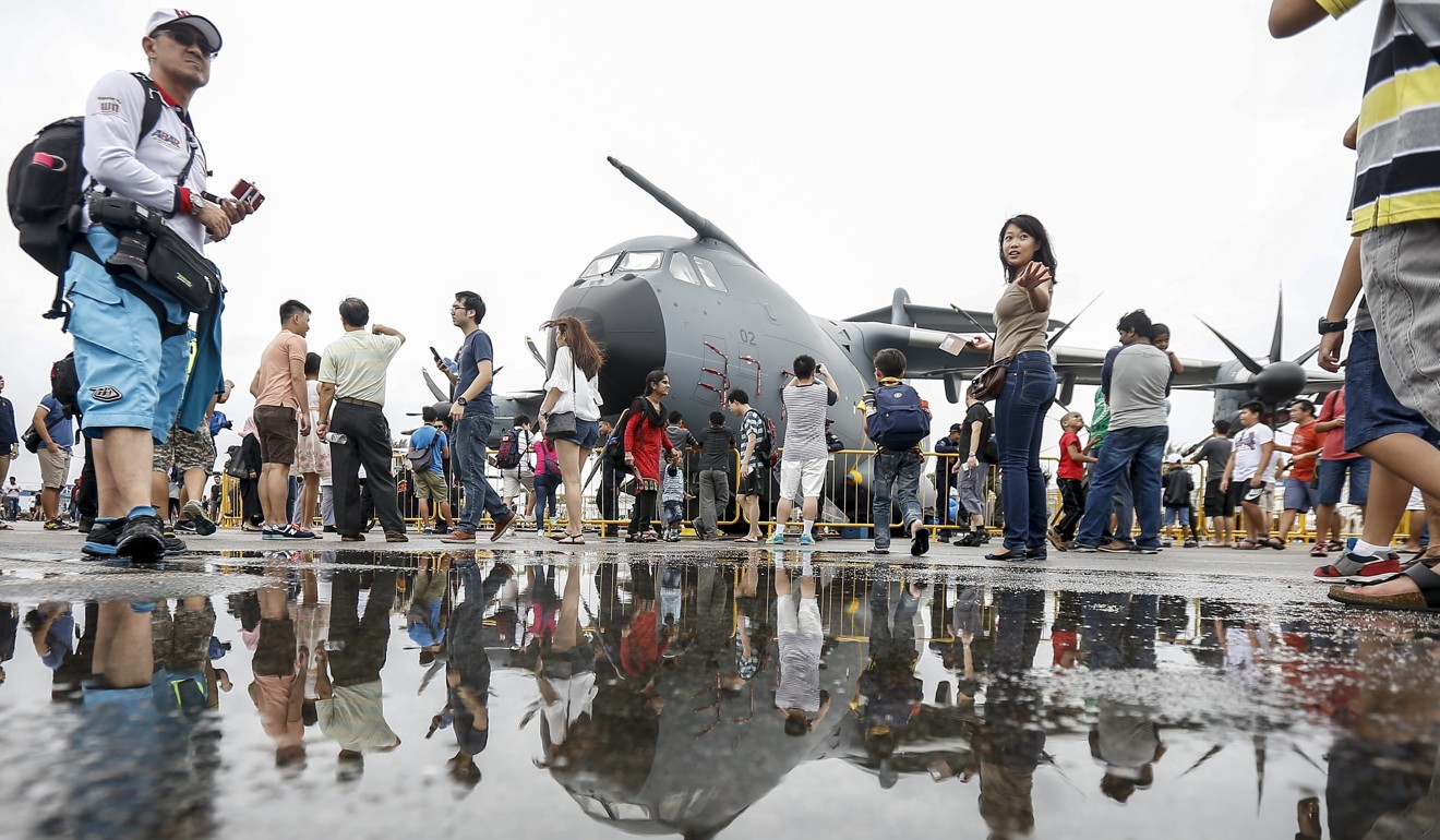 Visitors look at a transport aircraft during the 2016 edition of the Singapore Airshow. Photo: EPA