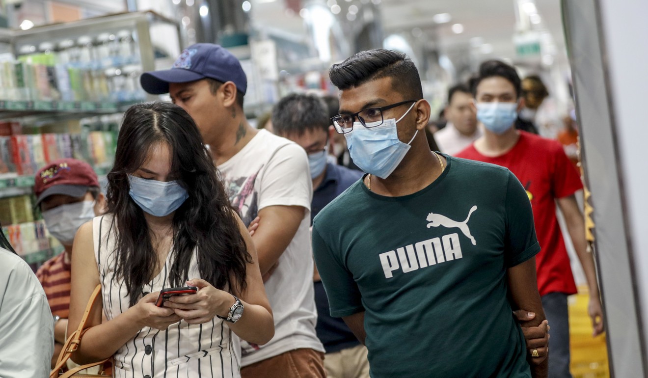Customers seen wearing protective masks walk at a shopping centre in Singapore on January 30, 2020. Photo: EPA-EFE