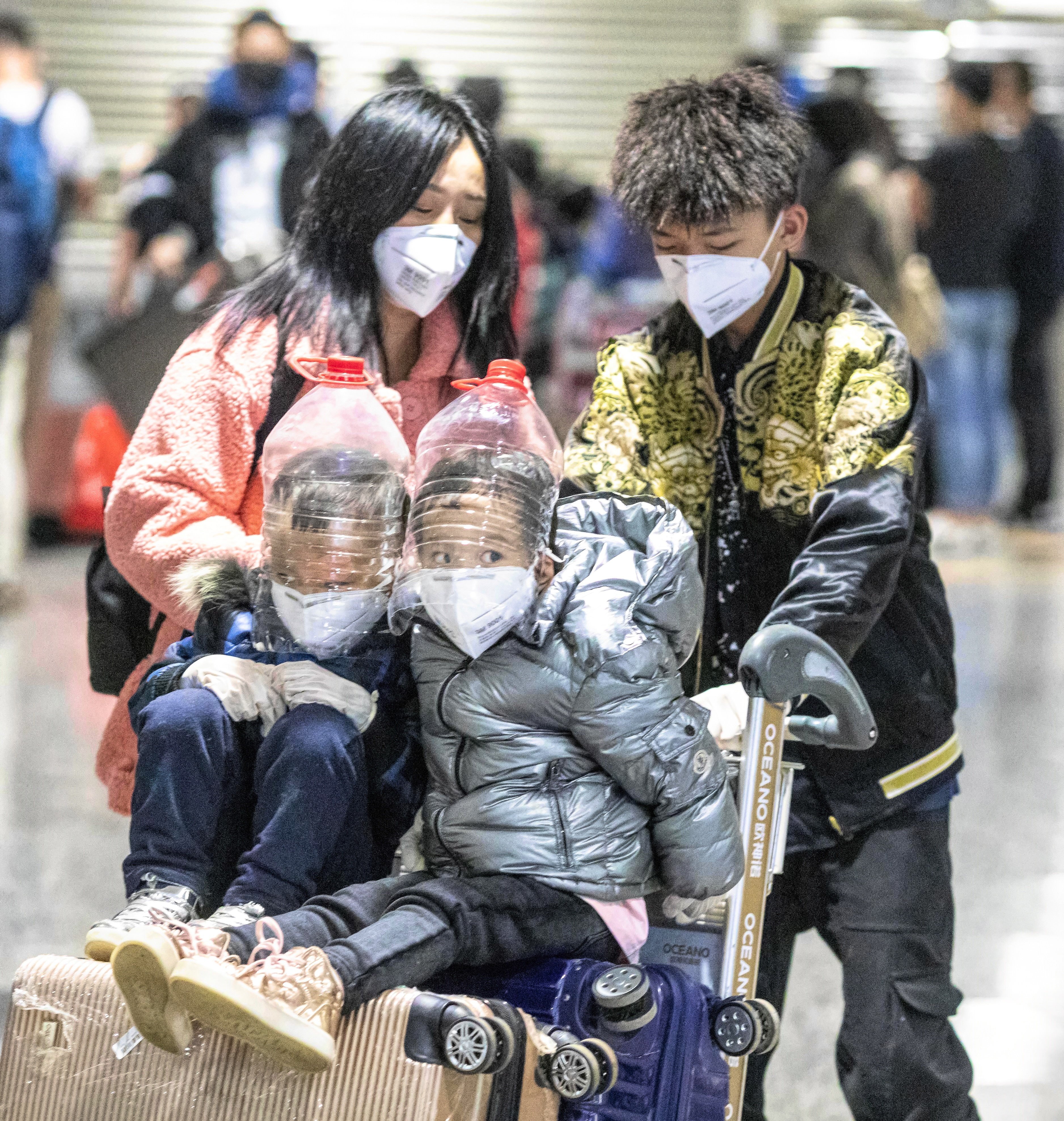 Children wear face protection improvised from water bottles at Guangzhou airport’s arrival terminal on February 1. Photo: EPA-EFE