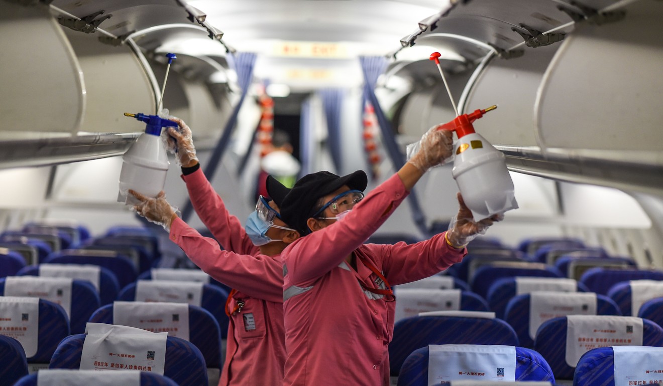 China Southern Airlines crew members disinfect the cabin of an aeroplane after its arrival at the Haikou Meilan International Airport in Haikou in southern China. Photo: Xinhua