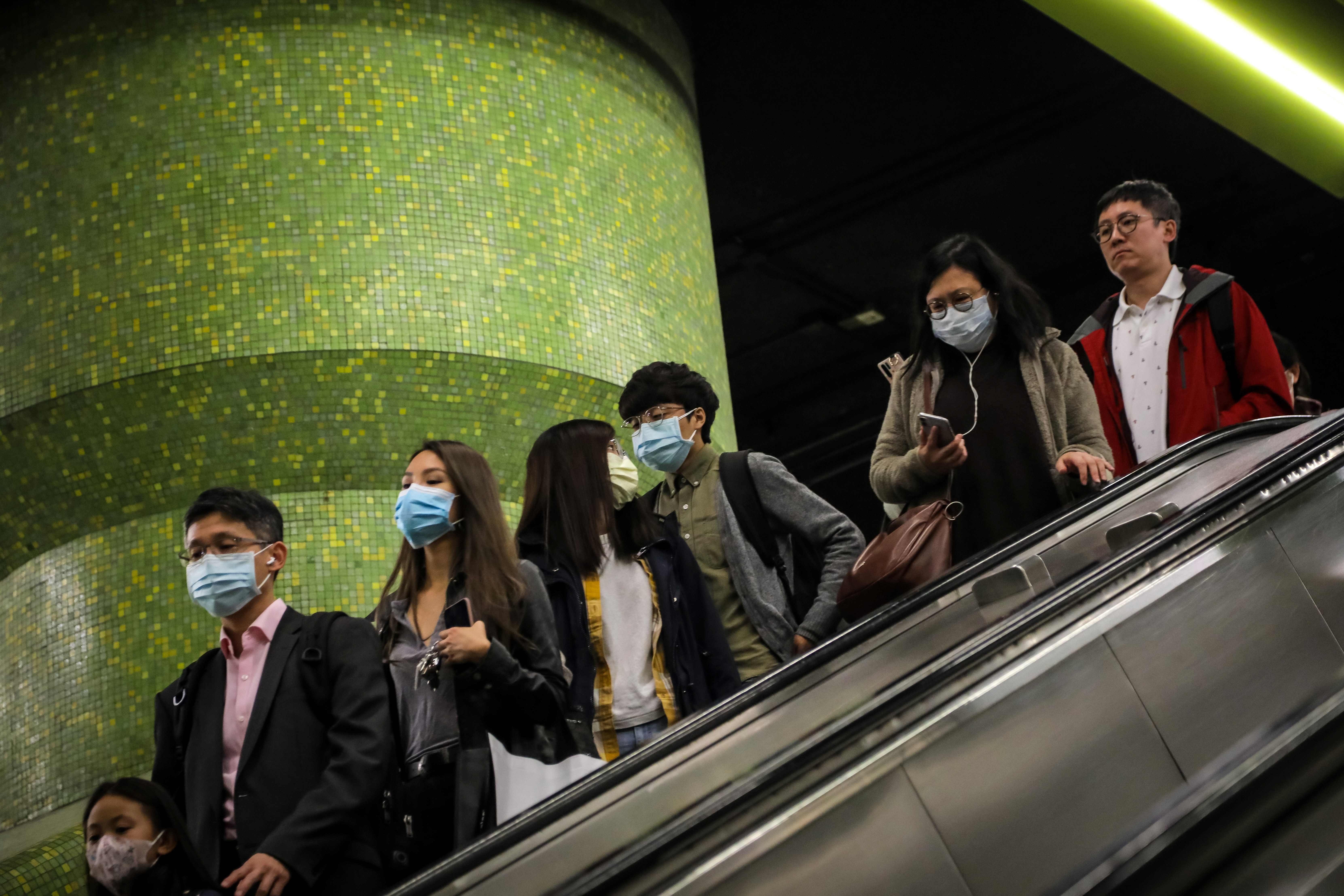 Commuters wear face masks as they ride an escalator at an MTR station on January 23. Photo: AFP