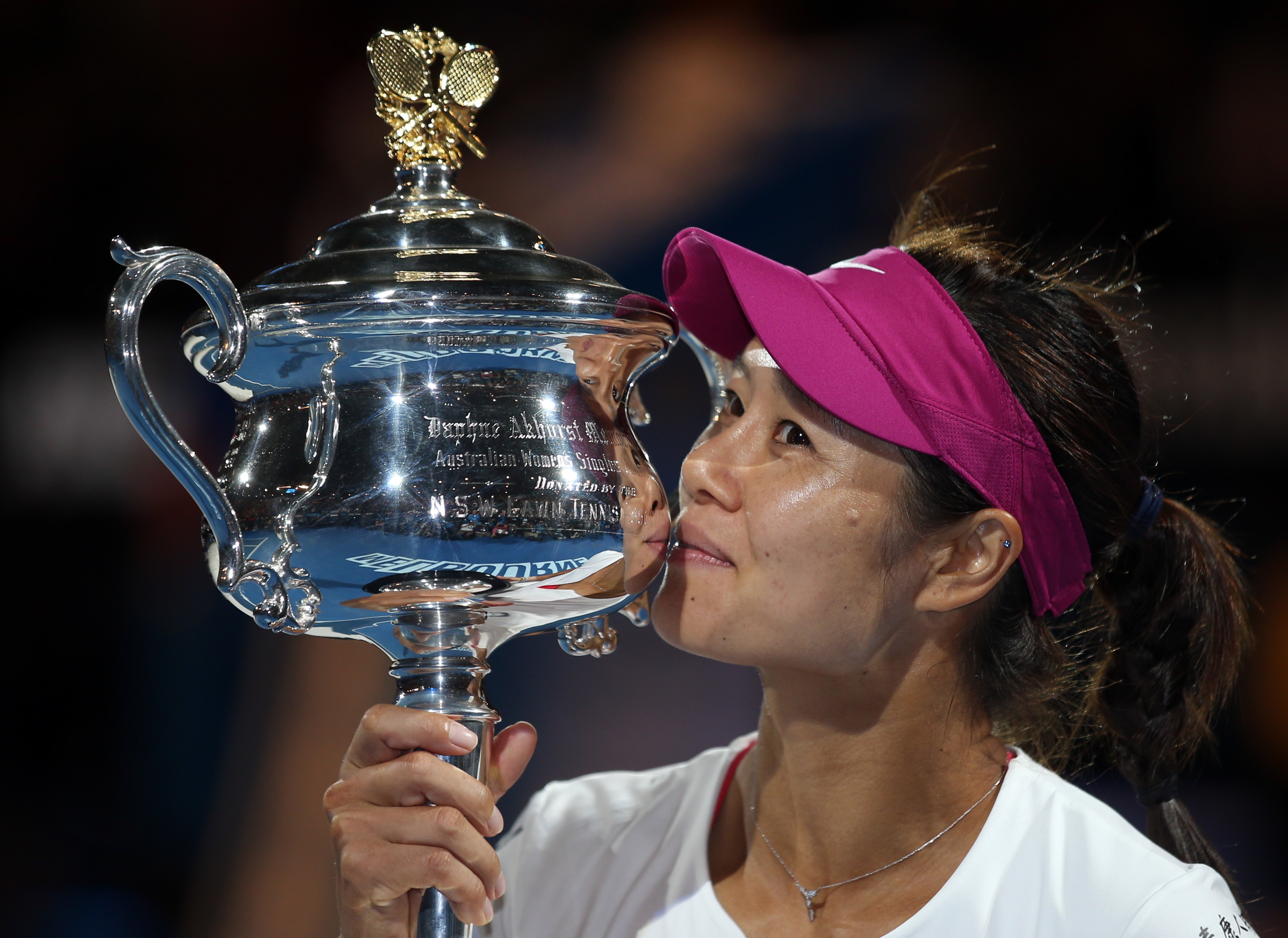 Li Na kisses the championship trophy after winning the 2014 Australian Open, her second grand slam title. Photo: AP