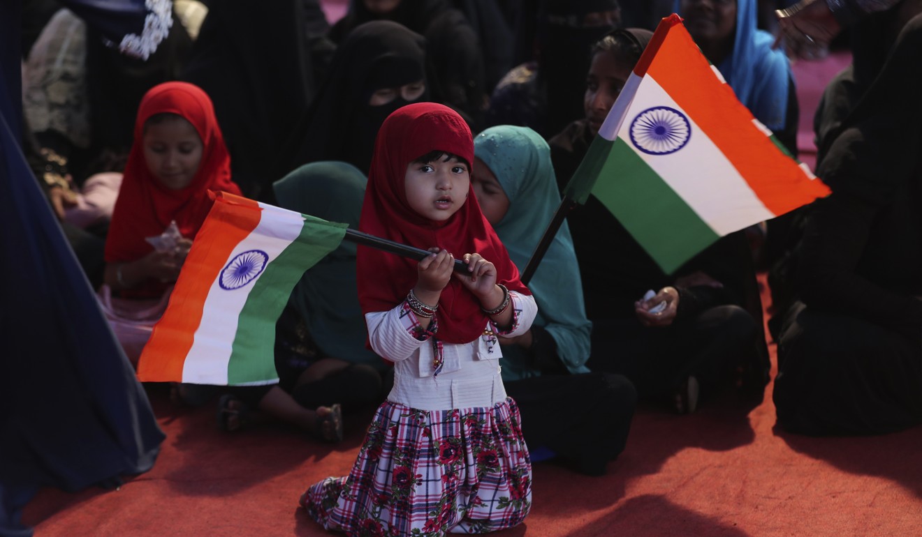 Indian Muslim girls hold national flags as they join elders in a protest against a new citizenship law in Bangalore. Photo: AP