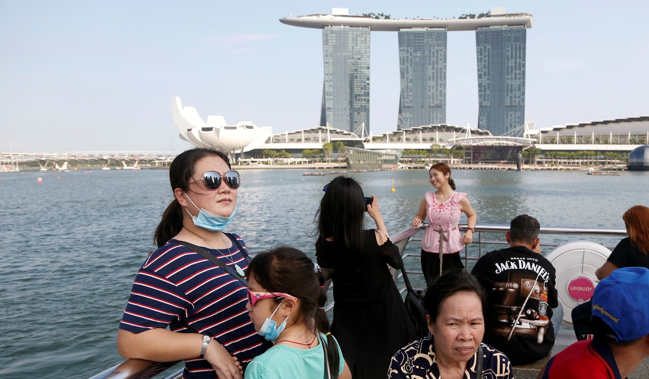 Tourists stand in front of the Marina Bay Sands in Singapore. Photo: Reuters