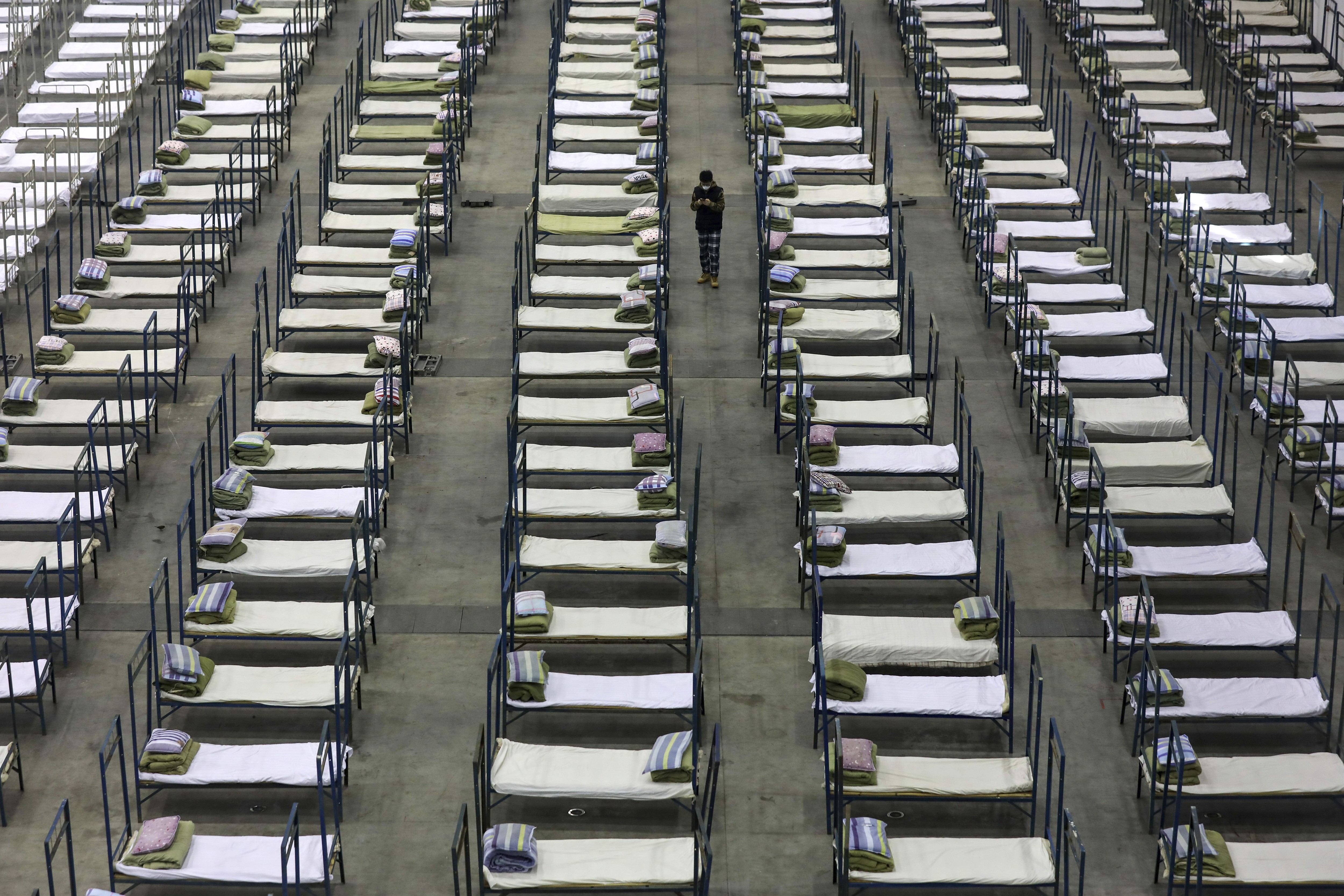 A worker walks among beds in a convention centre that has been converted into a temporary hospital in Wuhan, Hubei, on February 4. Photo: AP