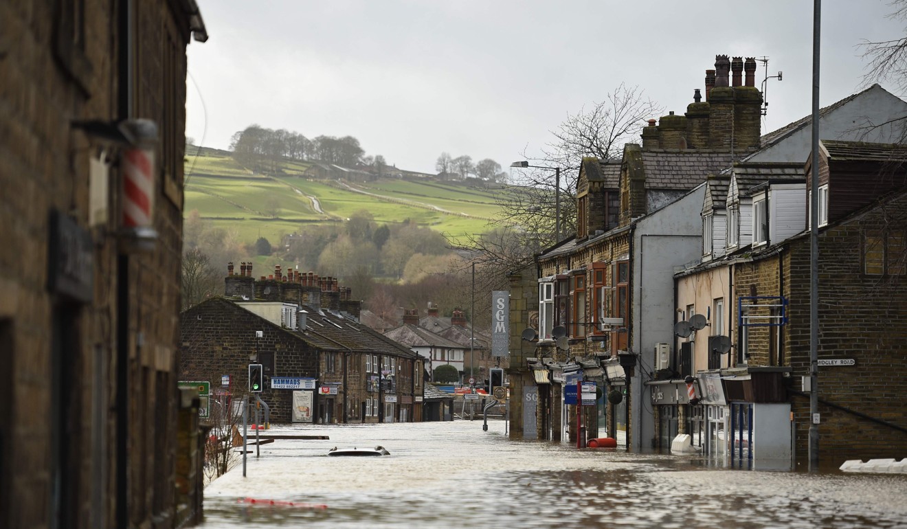 A car is seen submerged as flood water covers the roads in Mytholmroyd, northern England. Photo: AFP