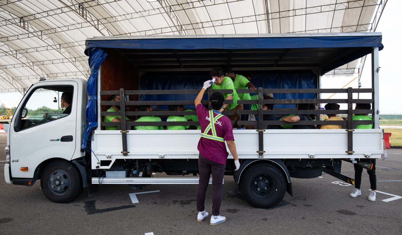 A medical staff member checks the temperature of a worker at a screening point at the air show in Singapore. Photo: Bloomberg