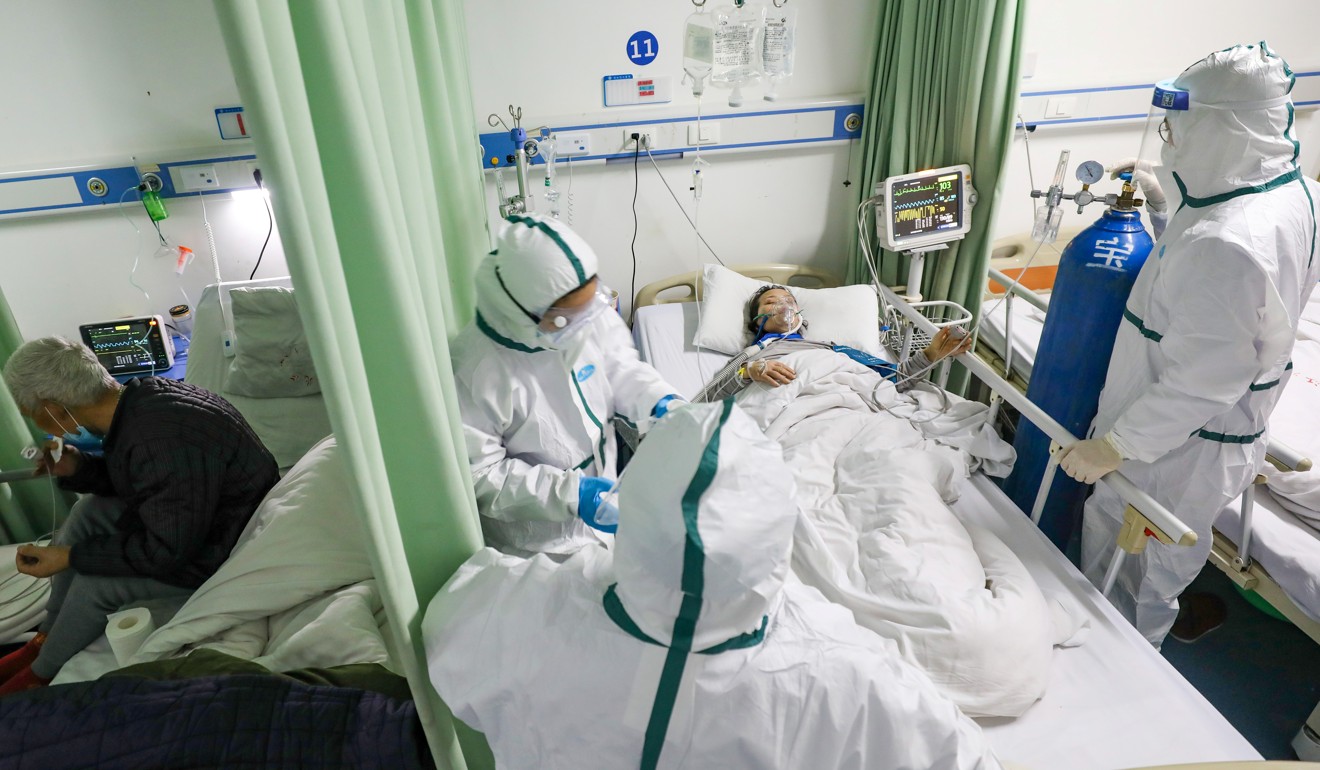 Medical workers in protective suits attend to a coronavirus patient at a designated hospital in Wuhan. Photo: Reuters