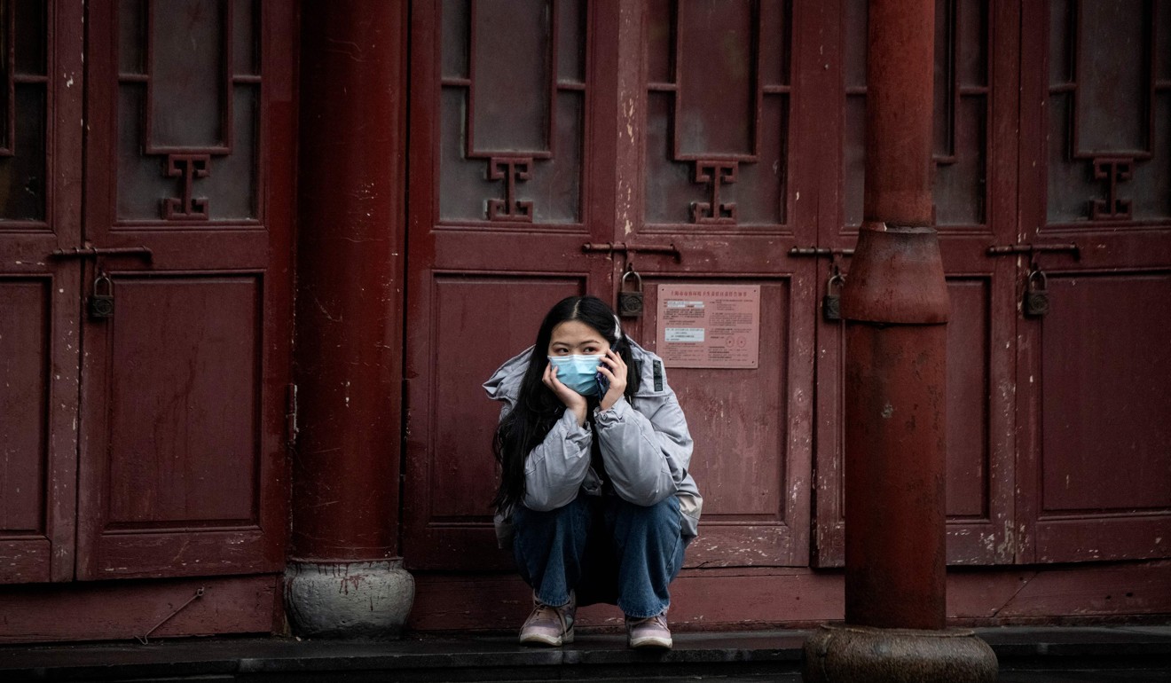 A woman wearing a protective face mask uses her mobile phone in Shanghai. Photo: AFP
