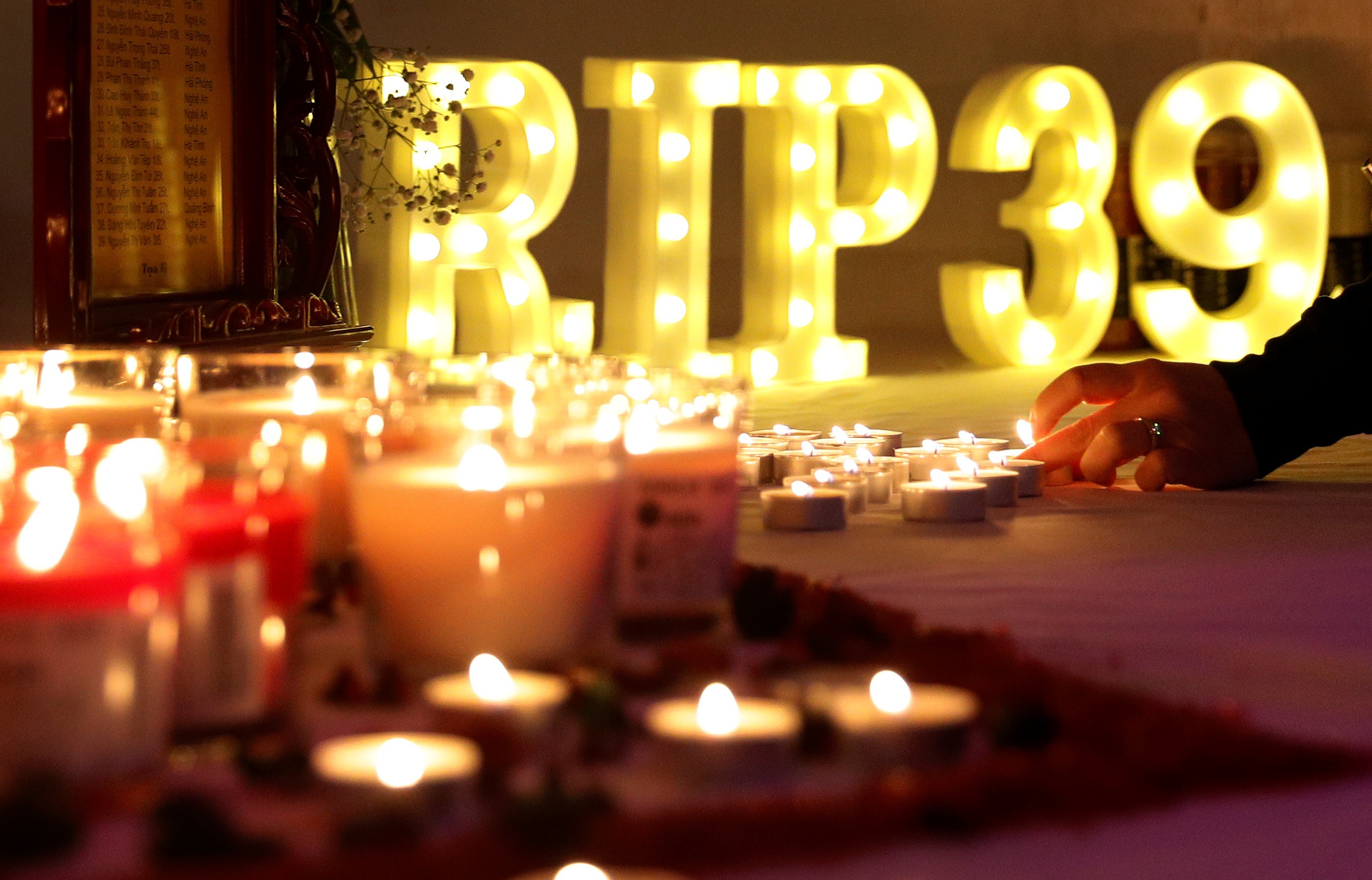 A woman lights a candle at a makeshift memorial during a fundraising event near Wolverhampton, Britain, in November for the families of the 39 victims found in a truck in Essex. Photo: Reuters