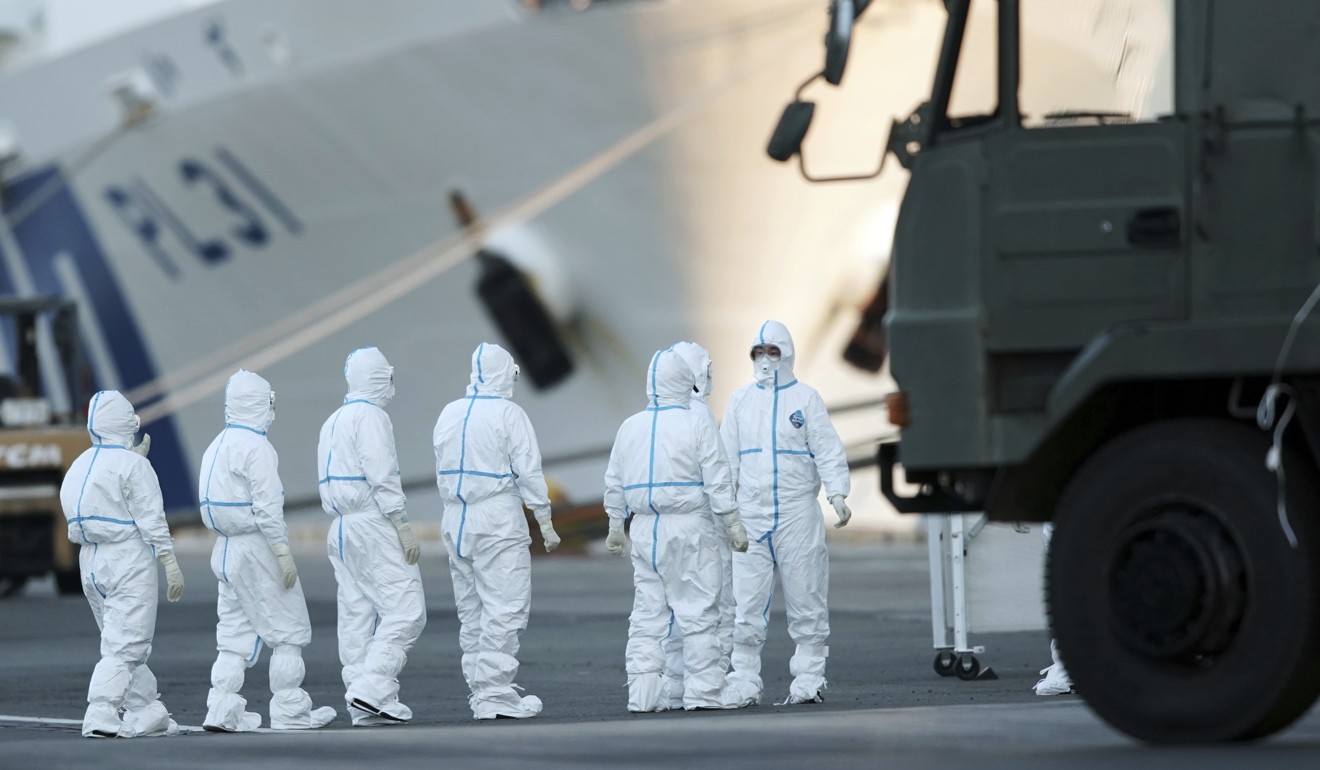 Officials wearing protective suits prepare to work around the cruise ship Diamond Princess, quarantined in Japan’s Yokohama, on Monday. Photo: AP